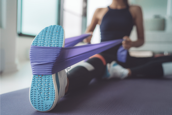 person using exercise band to stretch foot