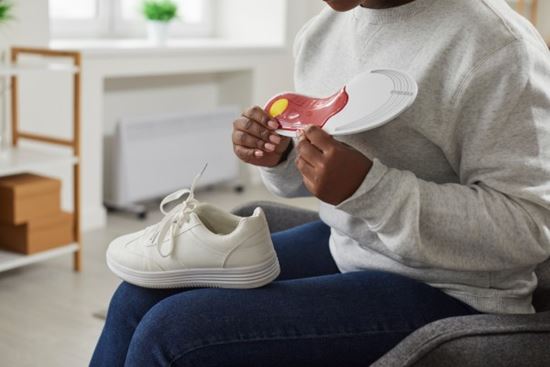 person putting arch support insole in shoe