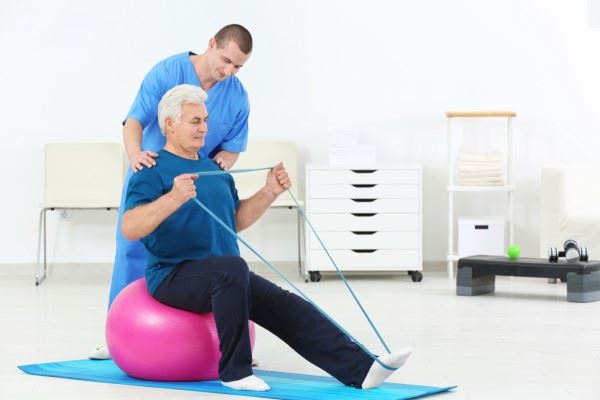 nurse helping patient with resistive band exercise