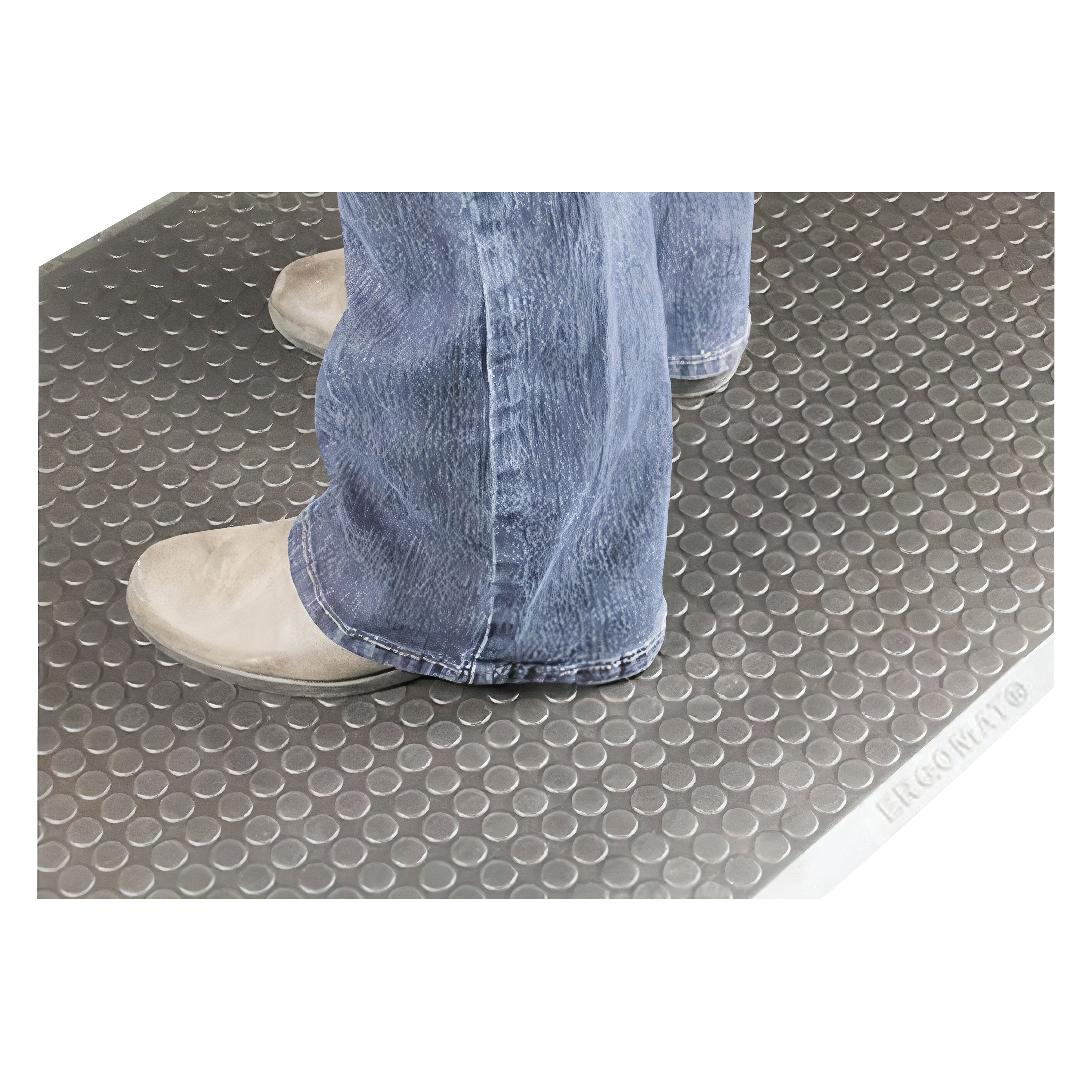 Someone stands on the ERGOMAT Basic Smooth Anti-Fatigue Mat wearing light gray shoes and blue jeans, showing its textured surface.