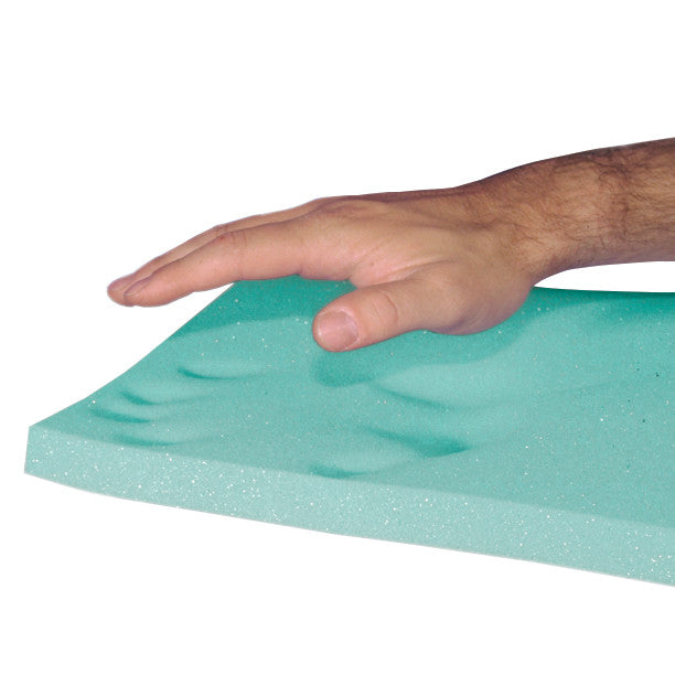 A hand presses on the AliMed T-Foam Uncovered Wheelchair Cushion, showing its green memory foam with visible hand impressions.
