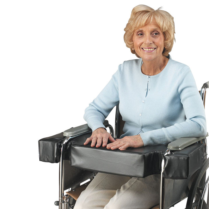 An elderly woman in a wheelchair uses the SkiL-Care LapTop Cushion with Desk-Arm Cutout, designed for an 18" wide wheelchair.