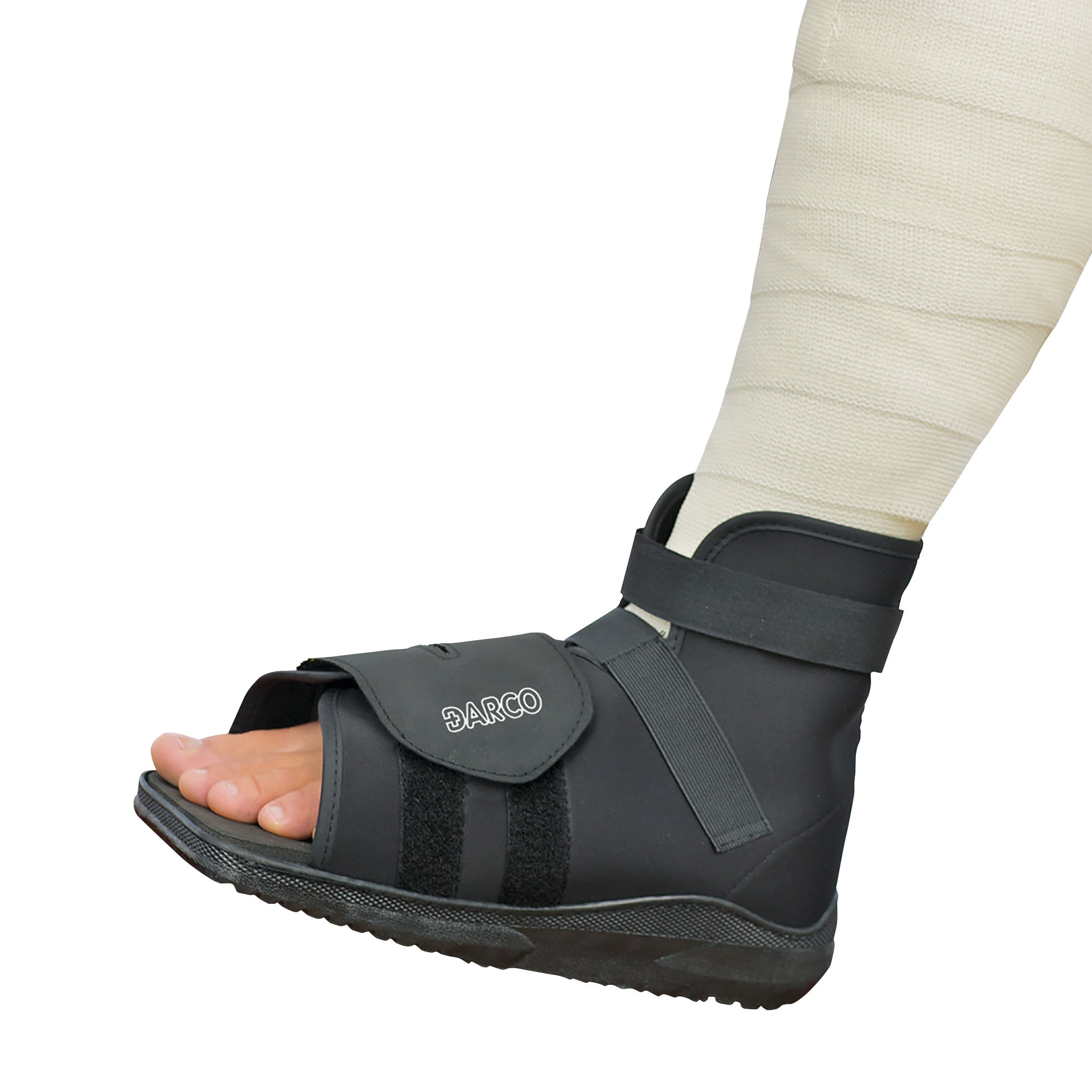 A DARCO Slimline Cast Boot, black with open toe design and straps, worn over a bandaged leg.