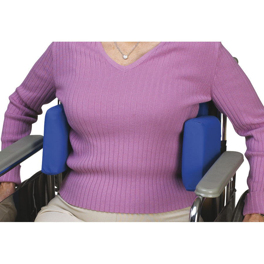 A person in a wheelchair uses the SkiL-Care Adjustable Lateral Support, featuring blue pads for torso stability and comfort.