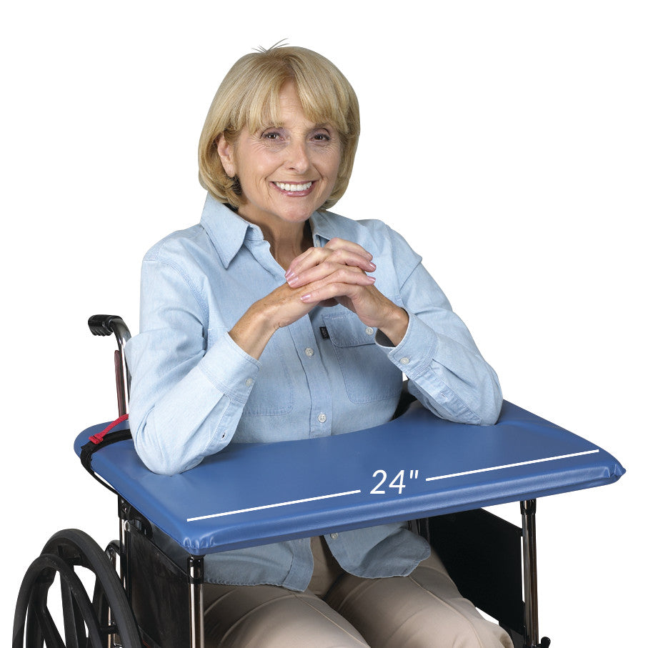 A person in a wheelchair uses the SkiL-Care SofTop Lap Tray, which is blue and measures 24 inches across.