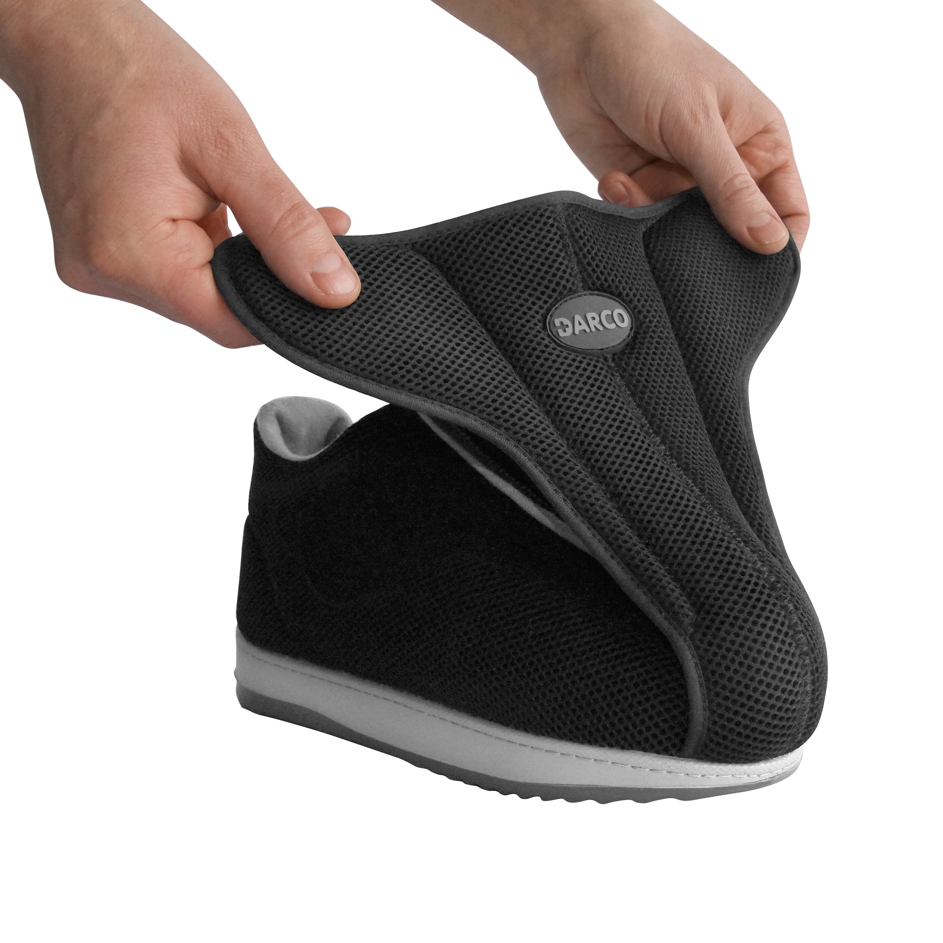Hands adjusting the DARCO AllRound Shoe with a soft black upper and wide opening, ideal for accommodating bandaged or swollen feet.