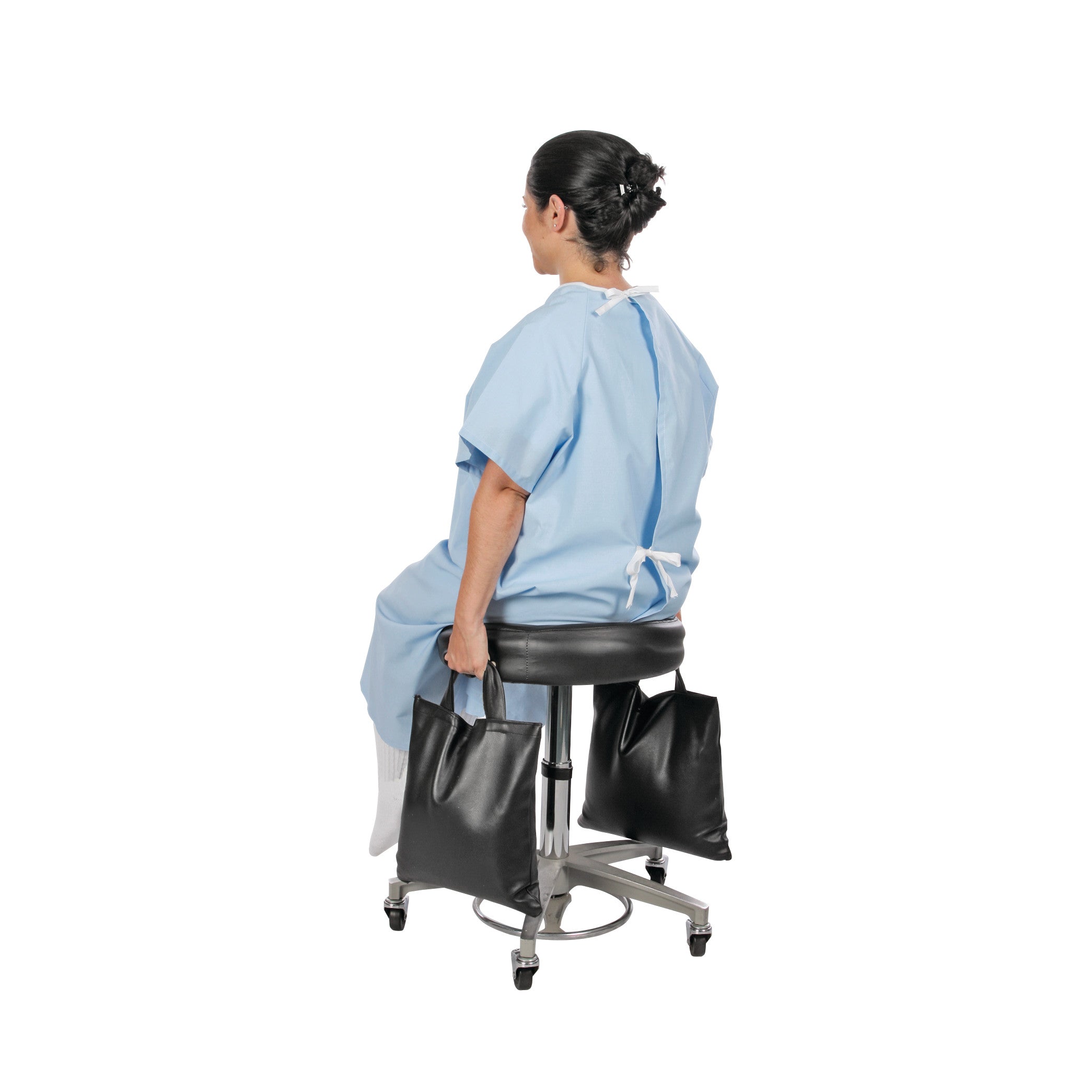 A person sits on a stool wearing a hospital gown. They hold two AliMed Cervical Visualization and Traction Sandbags.