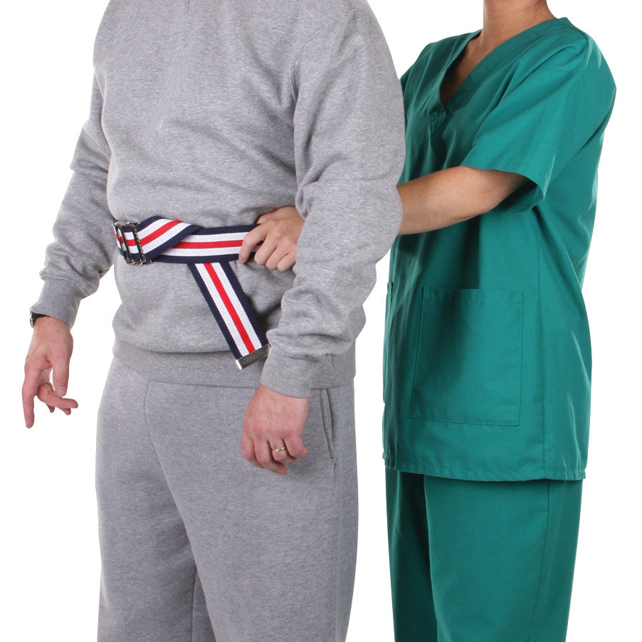 A person in scrubs assists another wearing a gray tracksuit with an AliMed Gait Belt. The belt is striped in red, white, and blue.