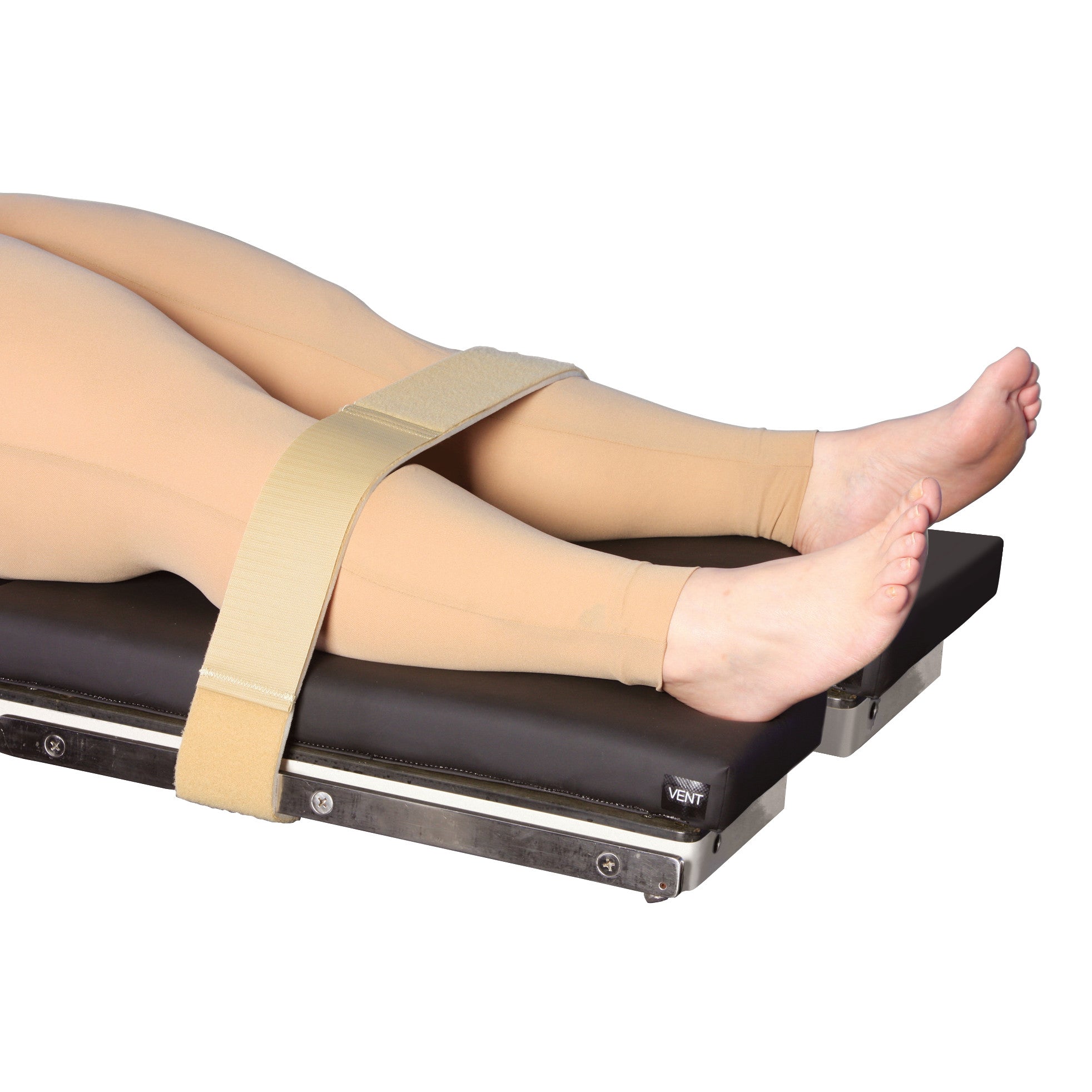A person's legs secured to a medical table with the AliMed Universal Econo-Strap, showing them in compression stockings.