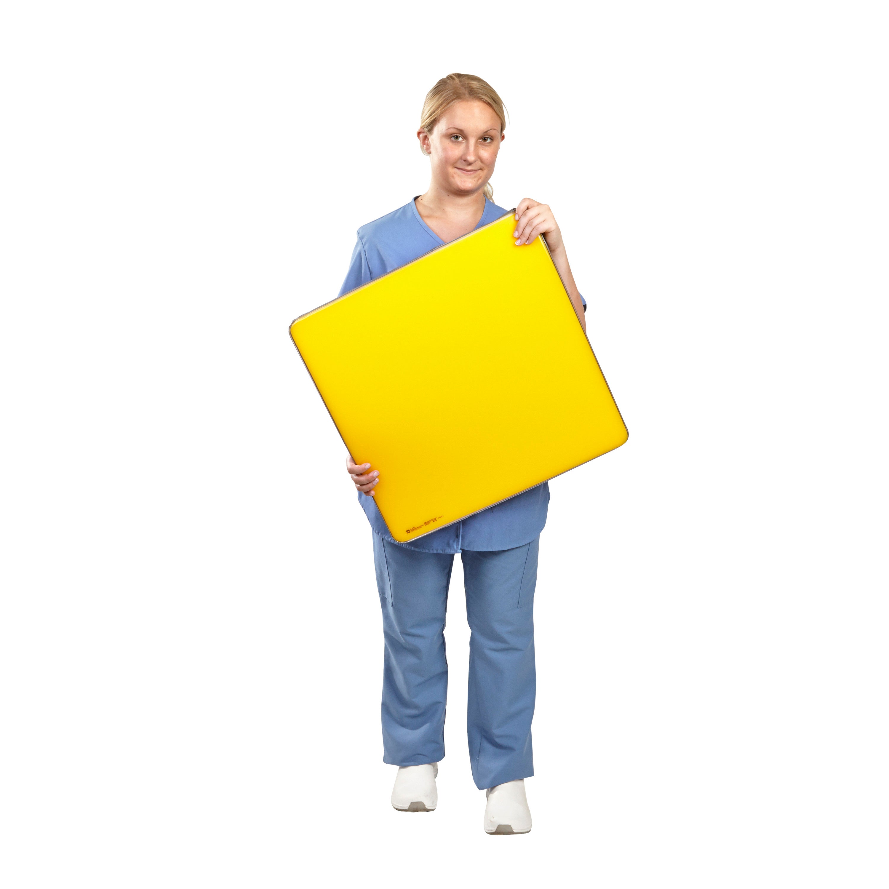 A person in blue scrubs holds an AliMed AliLite Surface Overlay, a large, square, yellow foam pad, against a white background.