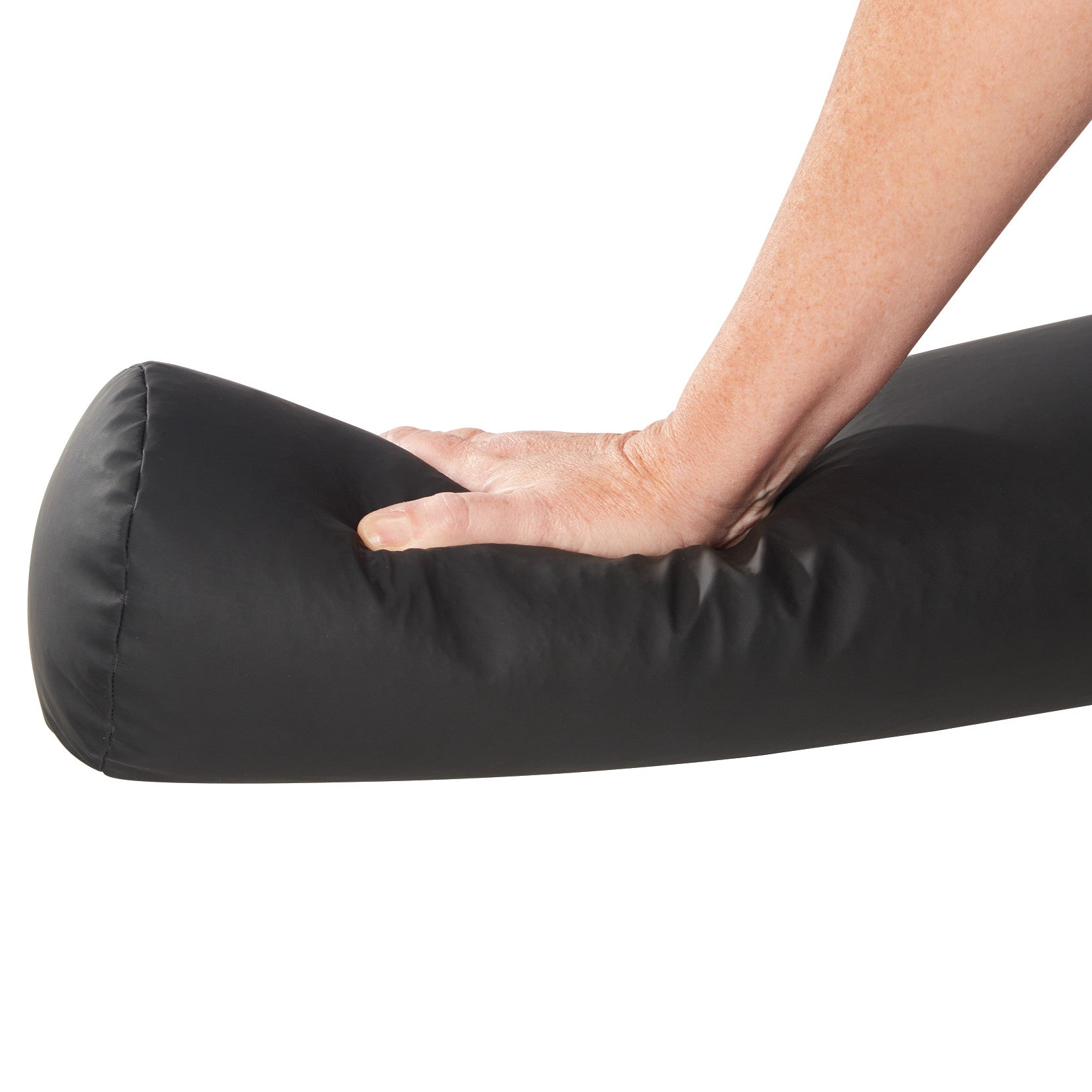 A hand presses on an AliMed ComPly Chest Roll Positioner, showing its softness. The positioner is black and cylindrical.
