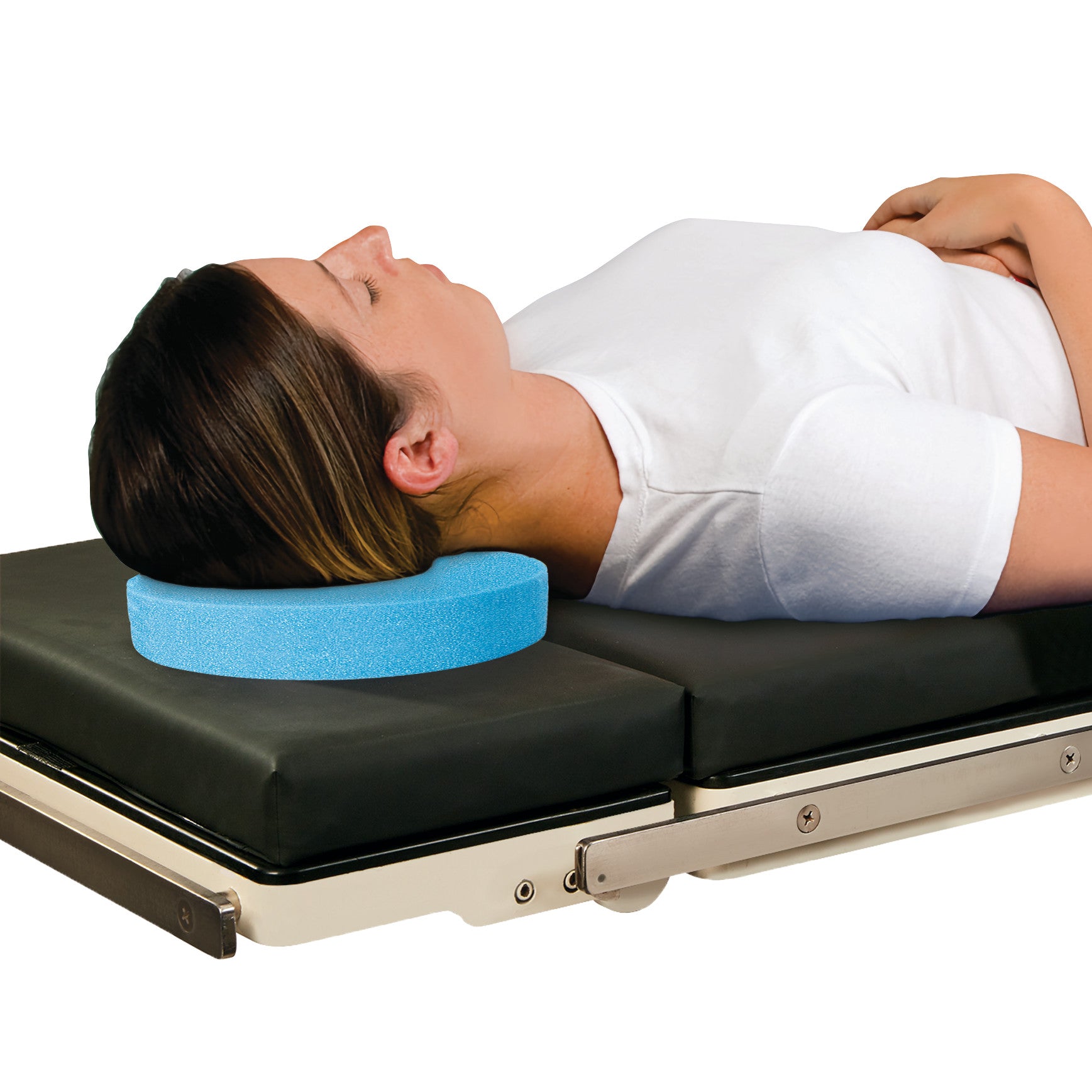 A person resting on a black table uses an AliMed Disposable Foam Head Donut for neck support. The donut is light blue and round.