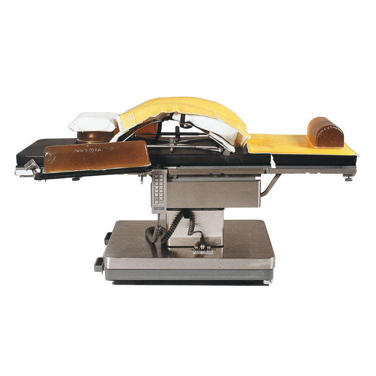 An operating table with the AliMed AliGel Wilson Pad Set, featuring yellow and brown cushioning for patient support.