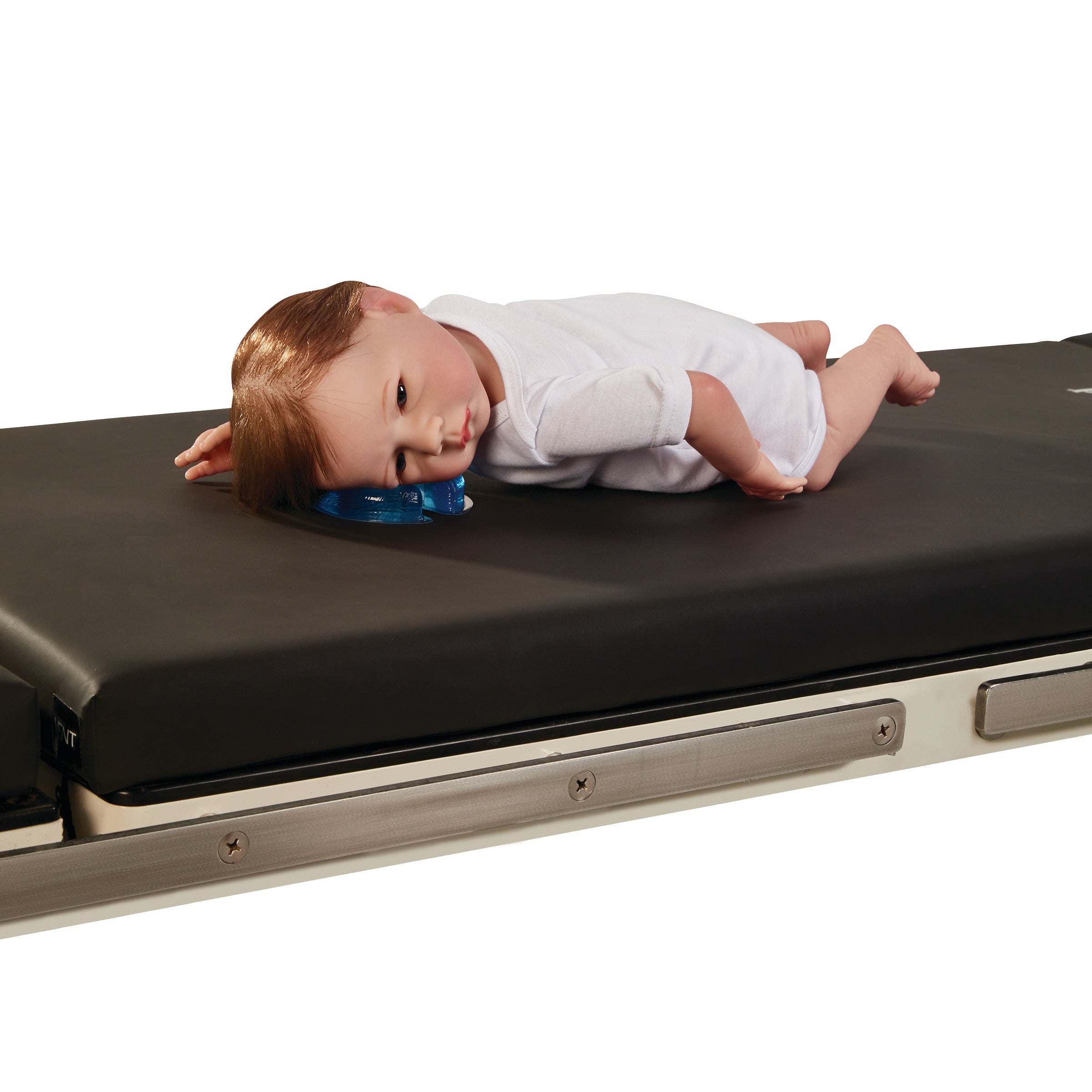 A mannequin is lying on a table using the AliMed AliBlue Gel Horseshoe Donut for head support, wearing a white outfit.