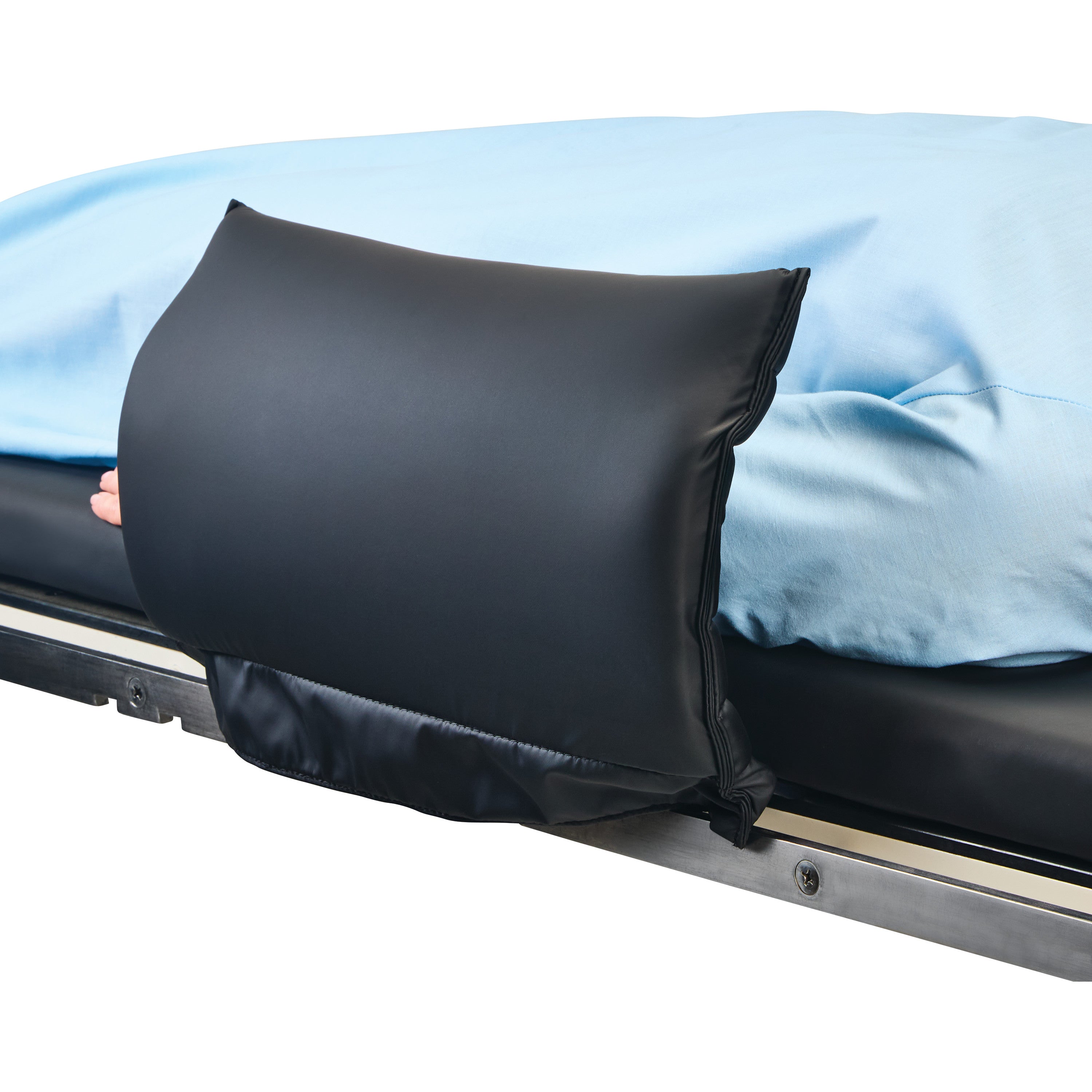 A hand adjusts the AliMed Padded Toboggan Cover, a black cushion on a bed, with blue sheets visible in the background.