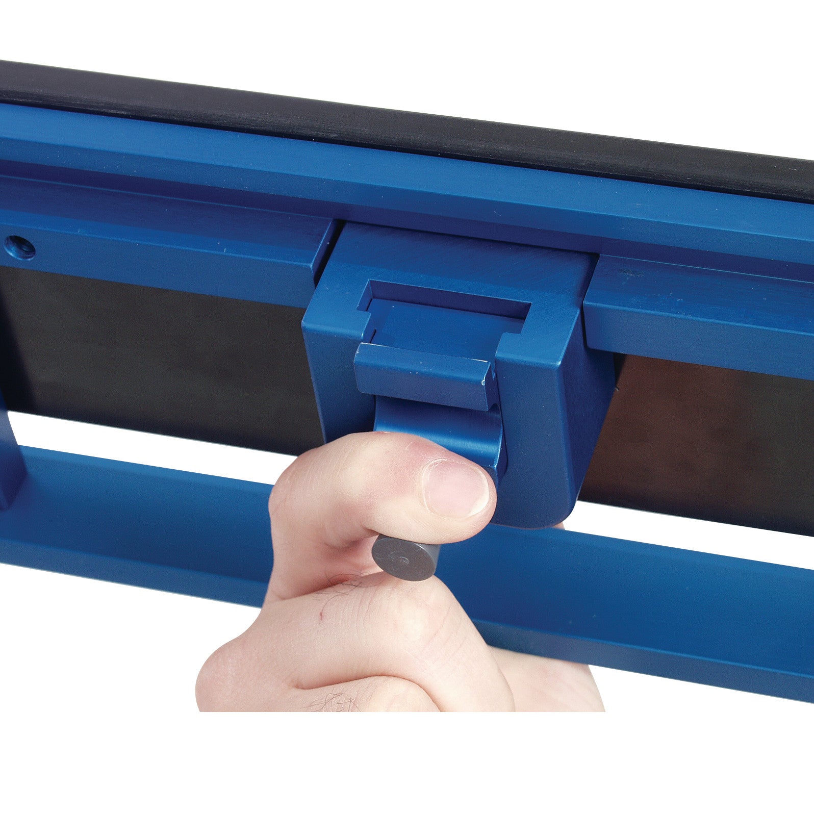 A hand is adjusting the AliMed FREEDOM O.R. Table Width Extender with Pad, featuring a blue metal and rubber design.