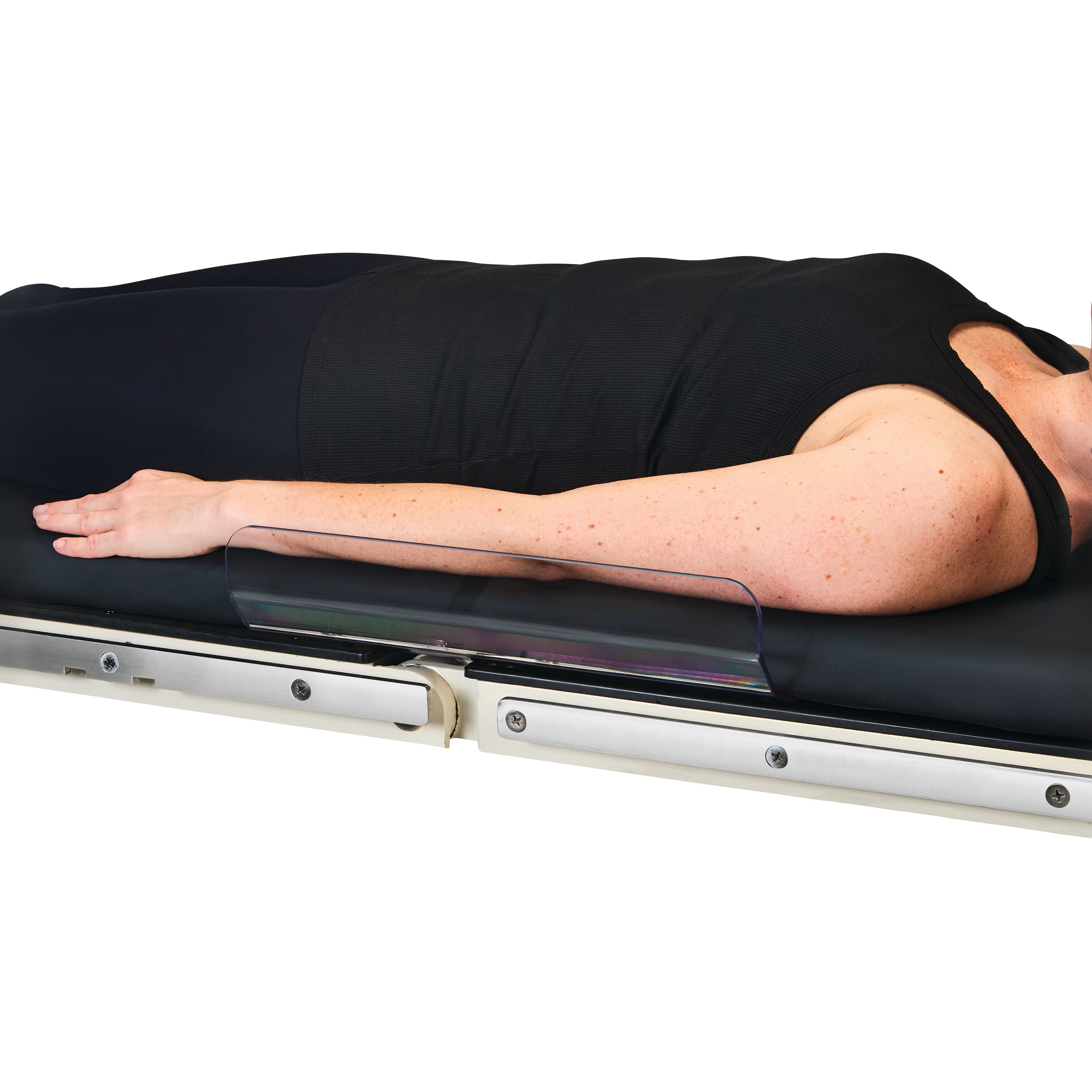 A person lies on a table using the AliMed Low-Profile Toboggan Arm/Leg Guard to secure their arm.