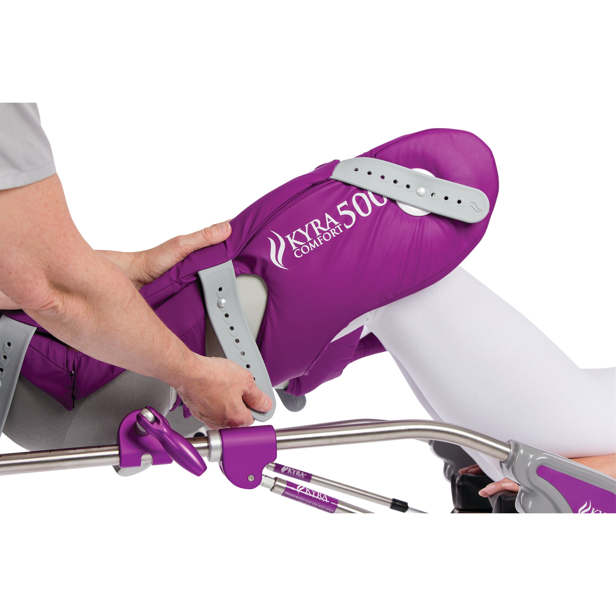 A person's leg rests in a KYRA Comfort 500 Lithotomy Stirrup with Secure-Lok Straps, adjusted by hands, showing the device in use.
