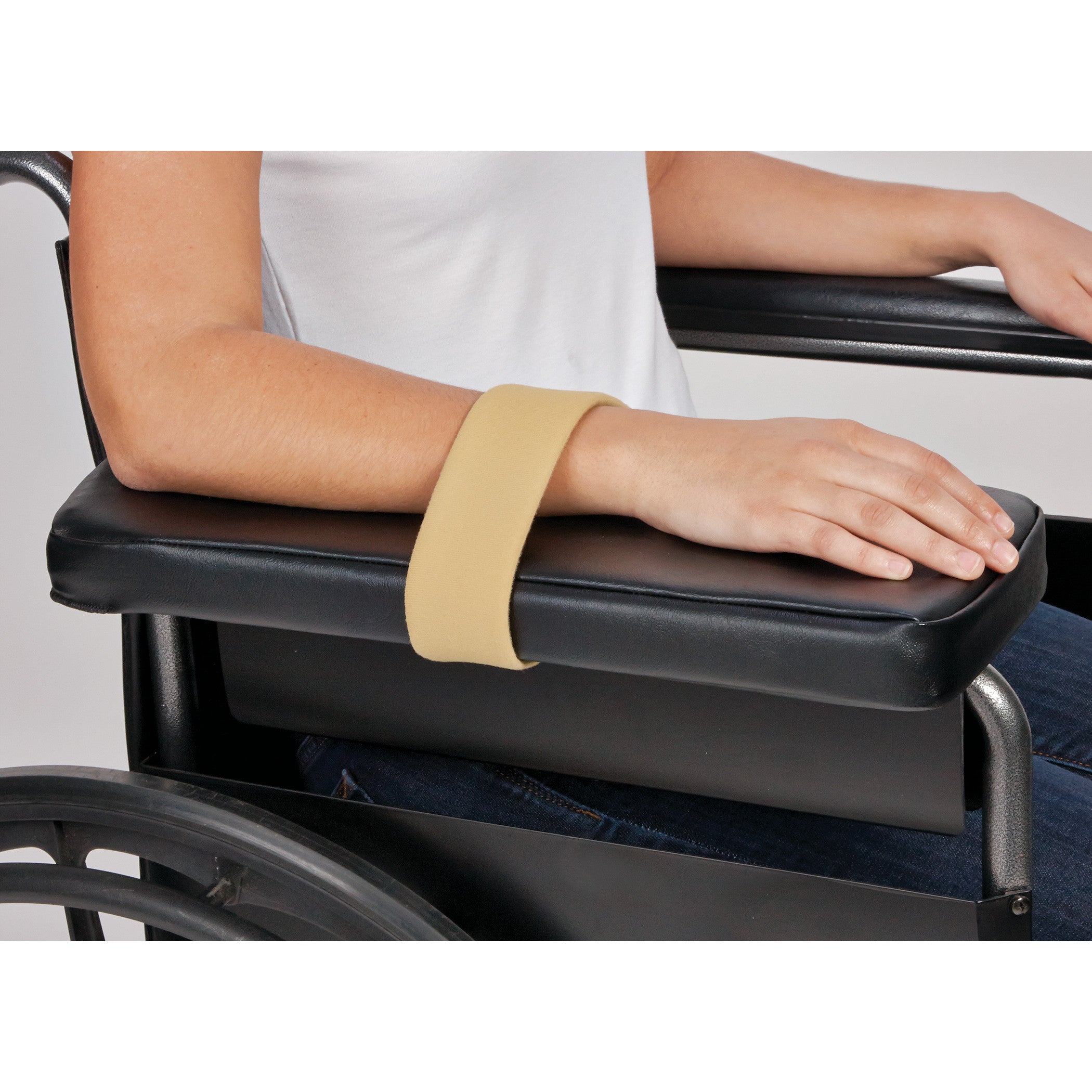 A person uses an AliMed Beta Pile II Loop to secure their arm on a wheelchair's black armrest.