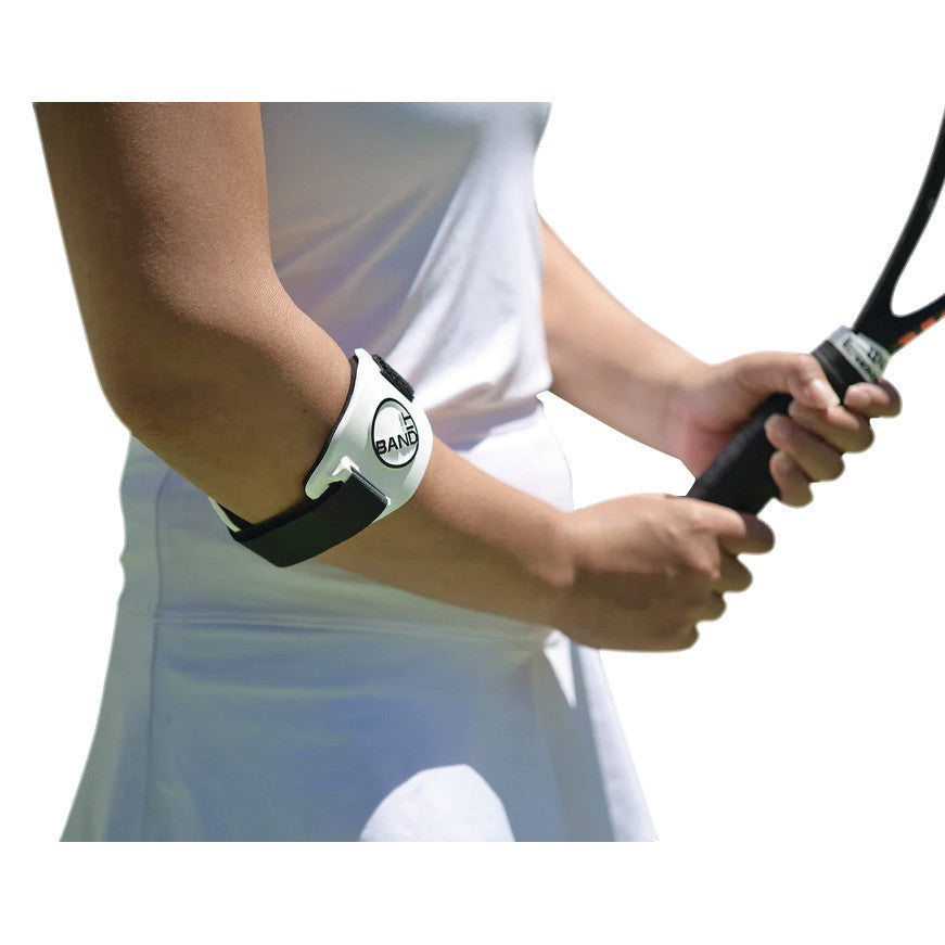 A person wearing a BandIT elbow brace holds a tennis racket. The brace is white with black straps.