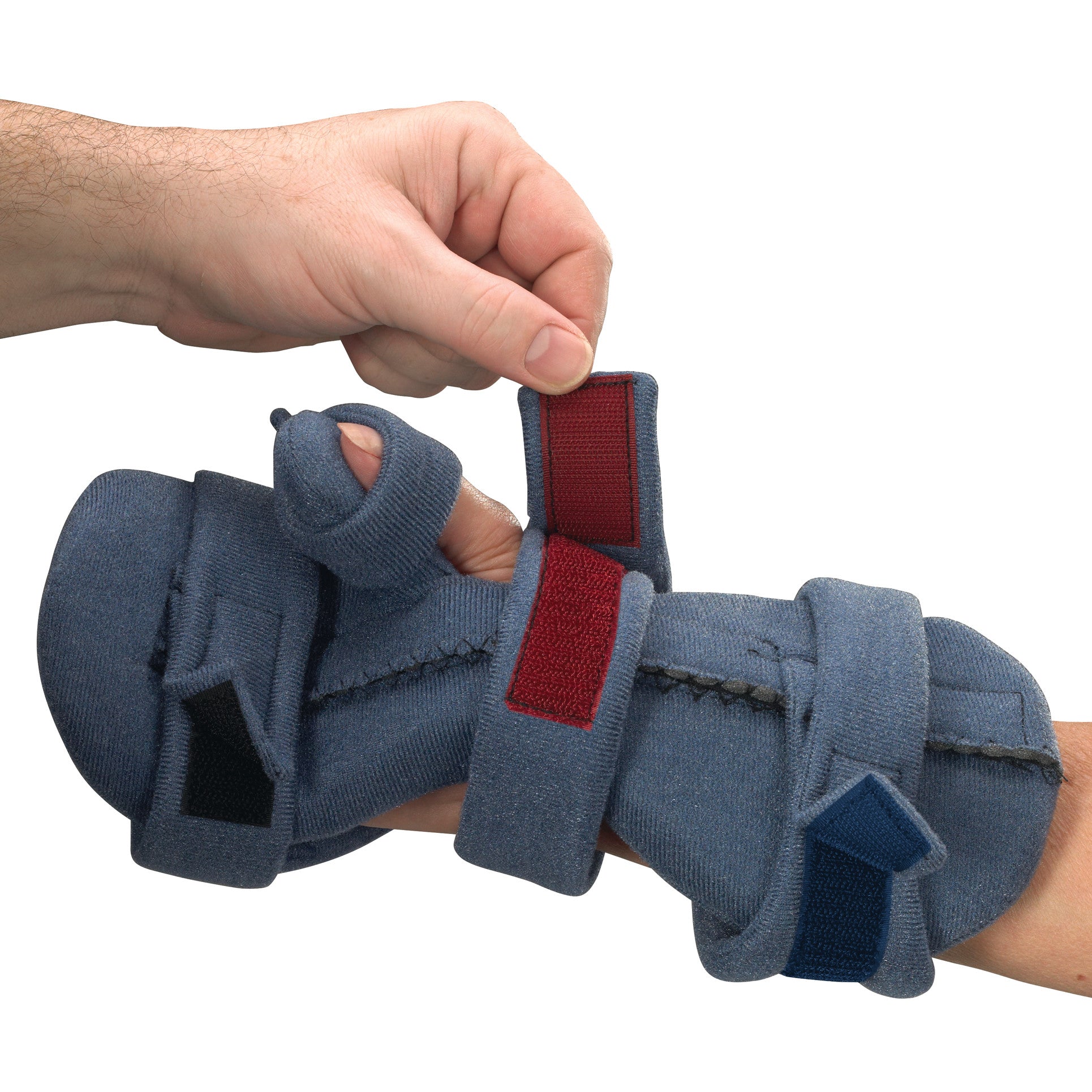 A hand adjusts the strap of the OCSI SoftPro Functional Resting WHFO, a blue orthopedic hand brace with red and blue straps.