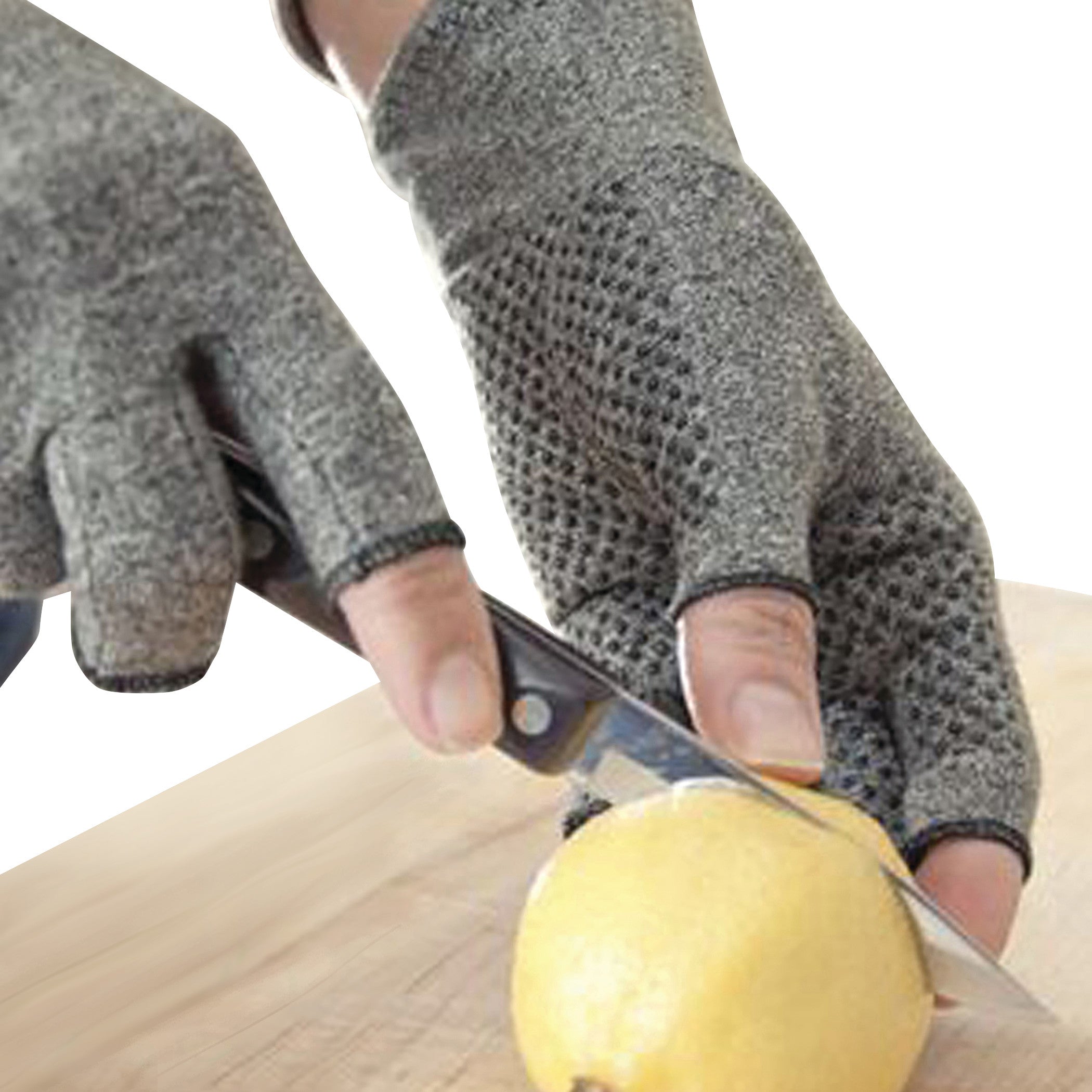 Hands wearing Brownmed IMAK Compression Arthritis Gloves are slicing a lemon on a wooden surface.