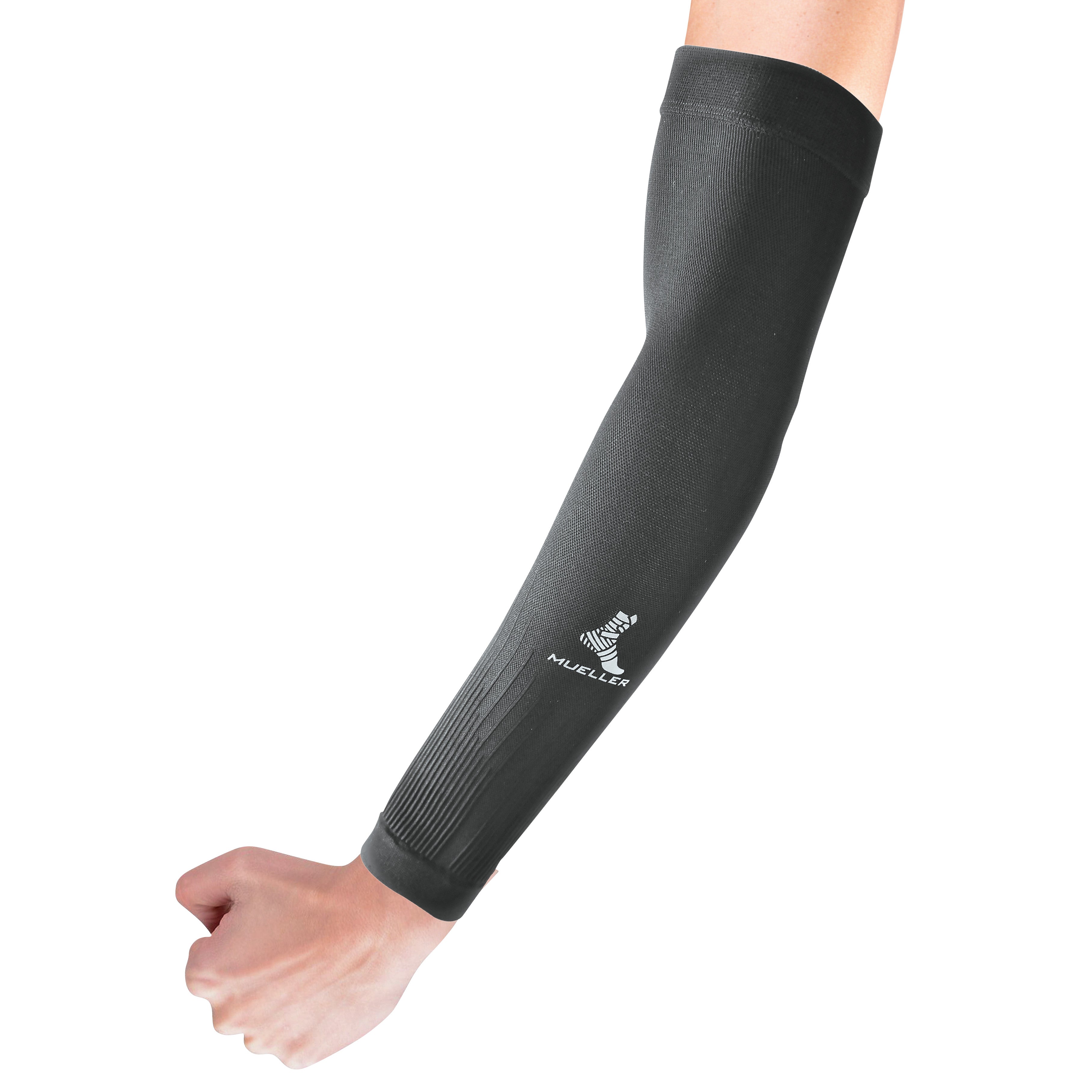A person wears a black Mueller Graduated Compression Performance Arm Sleeve, featuring a logo, covering from wrist to upper arm.