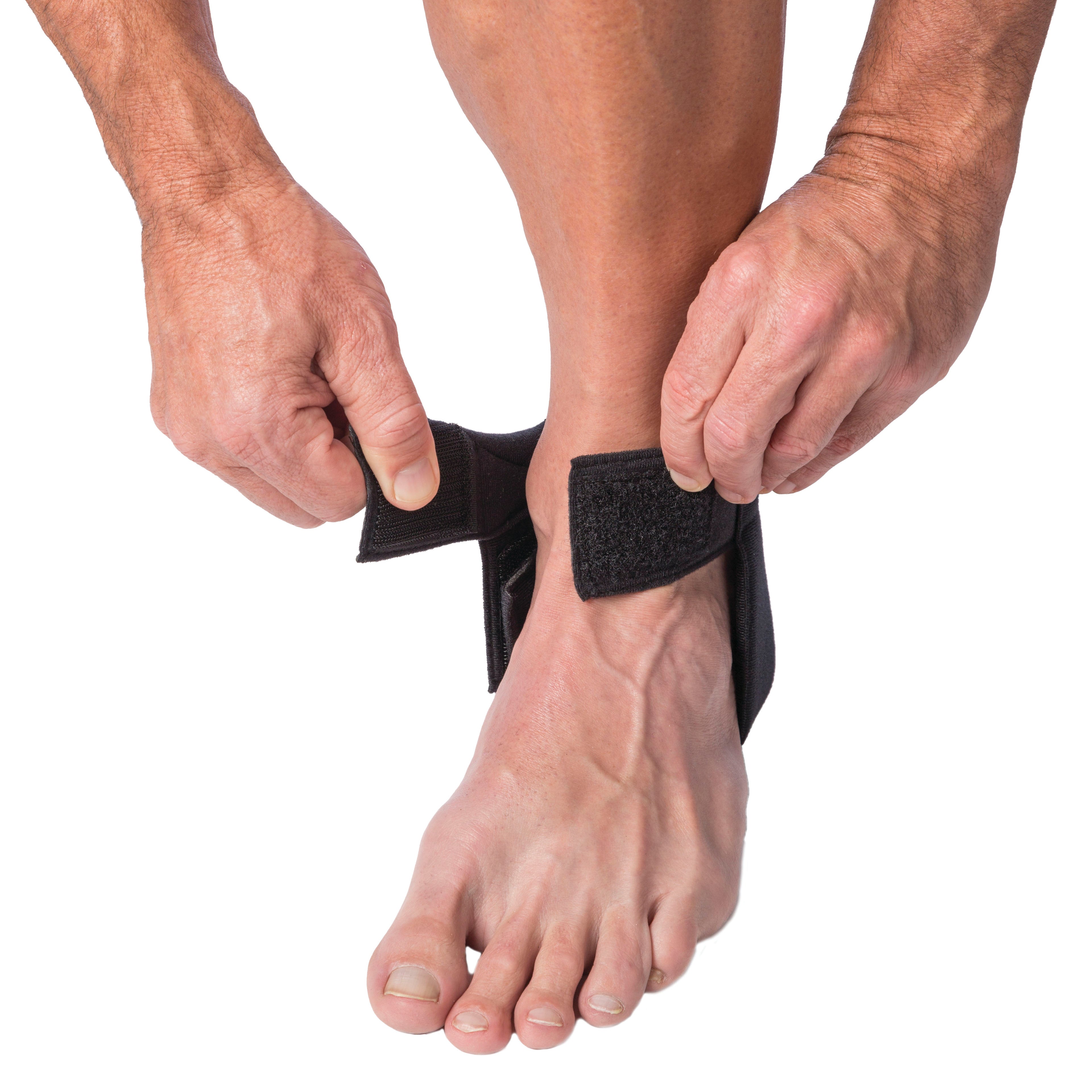 A person applies the Cho-Pat Achilles Tendon Strap to their ankle, fastening it with hook and loop