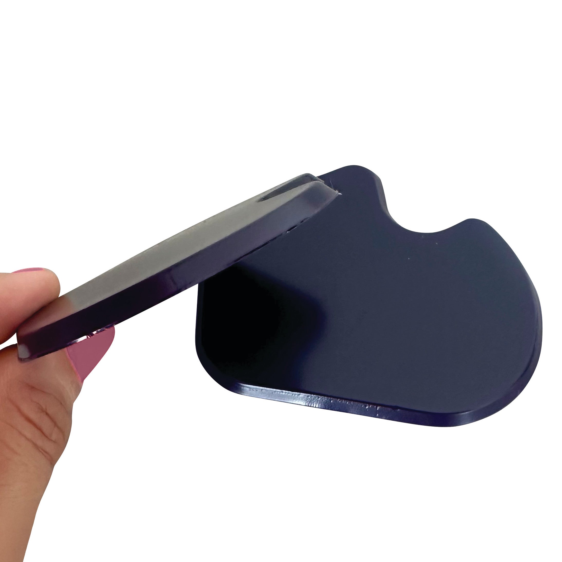 A hand holds a Gel Dancer Met Pad, a dark cushioned pad for foot support, showing its thickness and curvature in close-up.