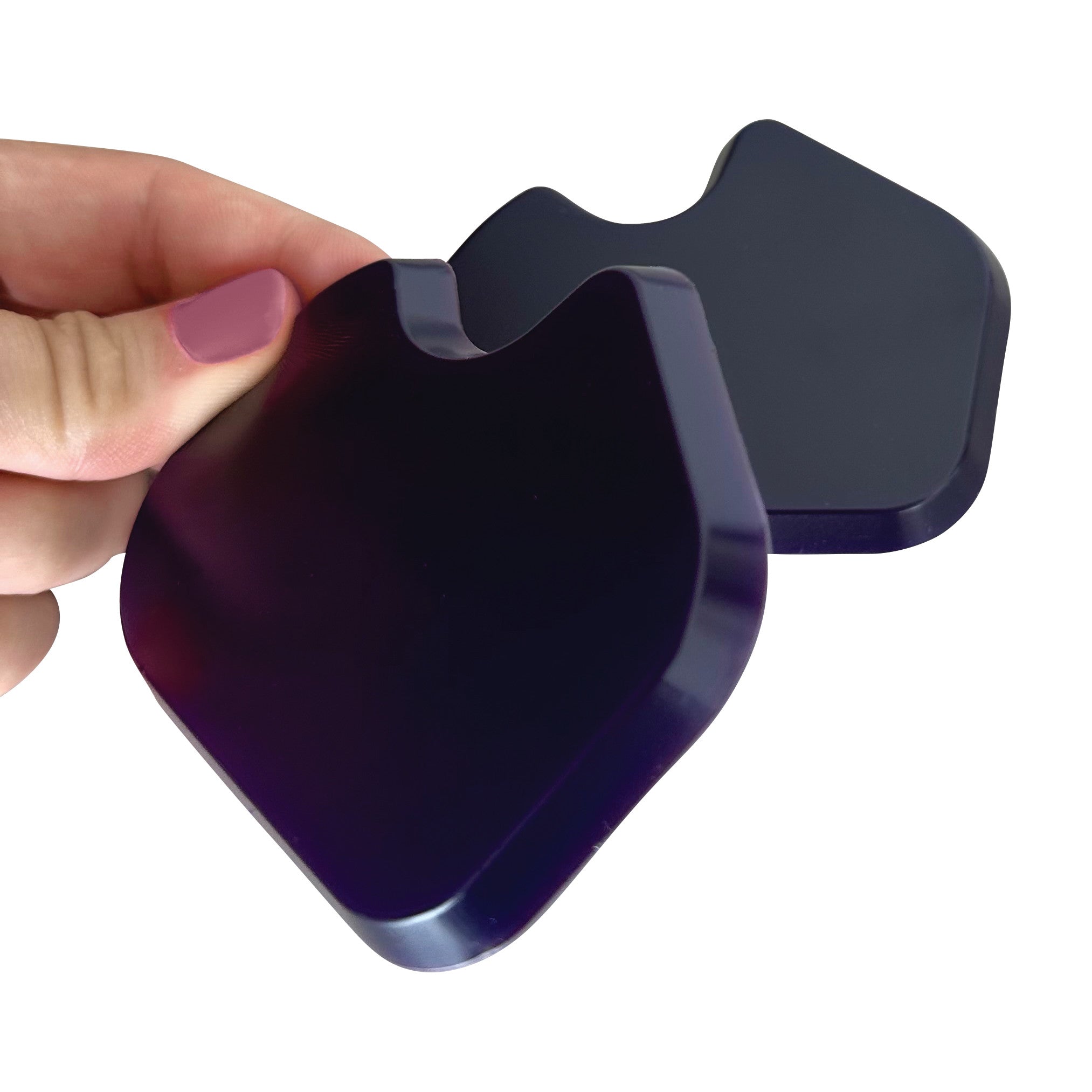 A hand holds two purple Gel Dancer Met Pads, shown in close-up. The pads have a smooth, contoured shape.