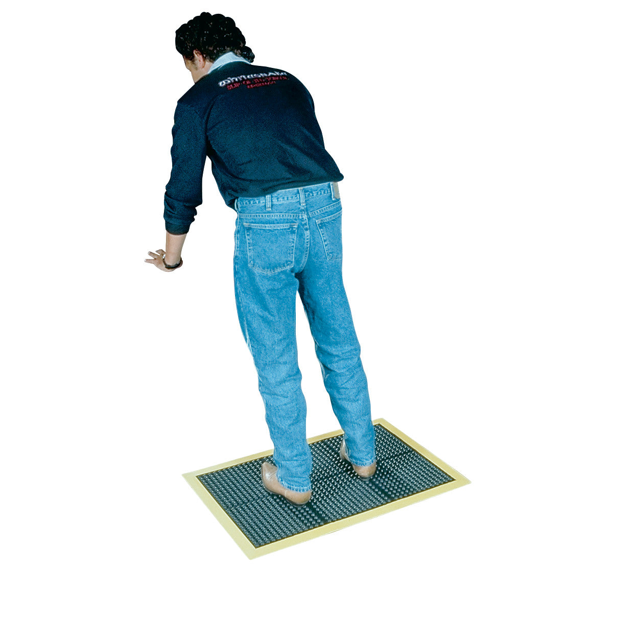 A person stands on a Wearwell Ortho Stand Anti-Fatigue Mat. The mat has a textured surface and a contrasting border.