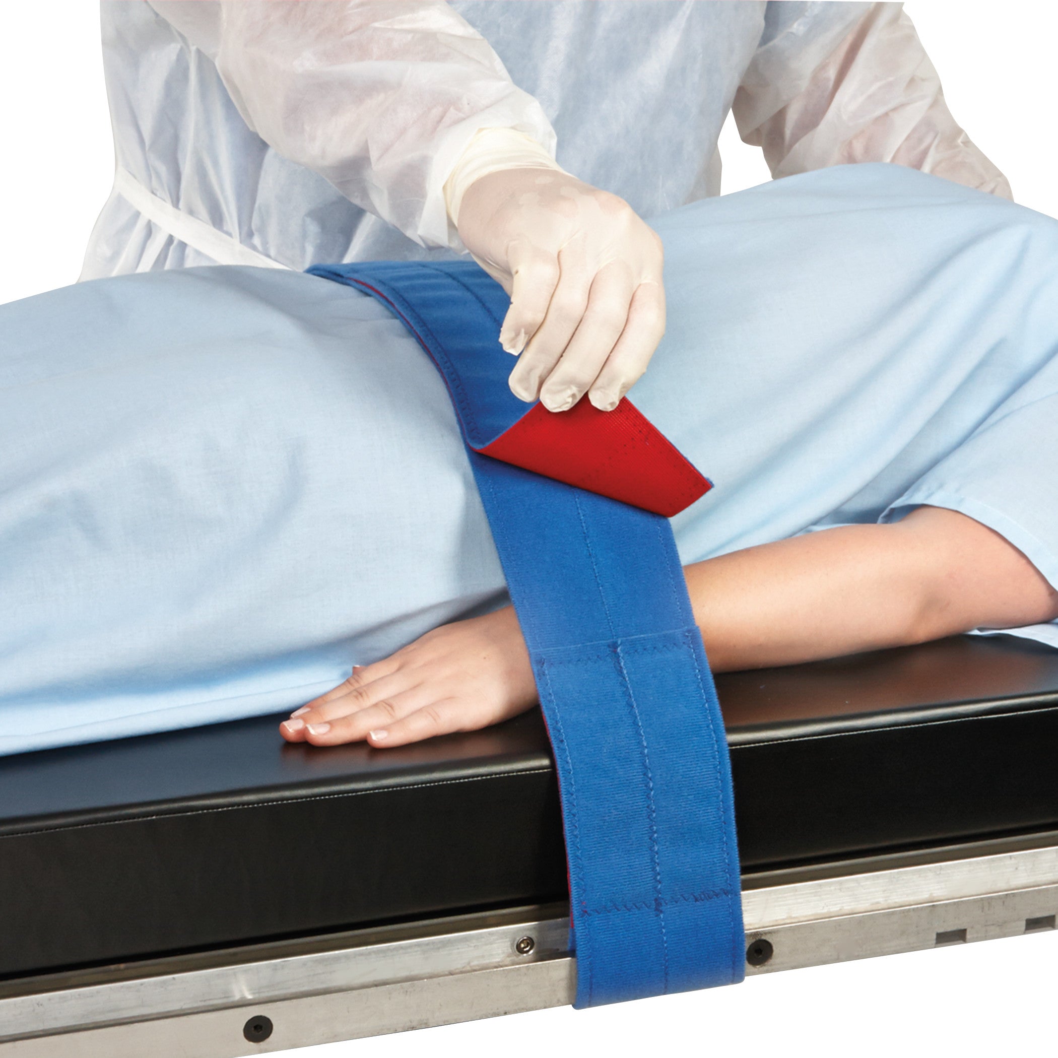 A person secures a patient with the AliMed Universal Strap, Two-Piece, Three Closures, Side Rail Hold on a medical table.