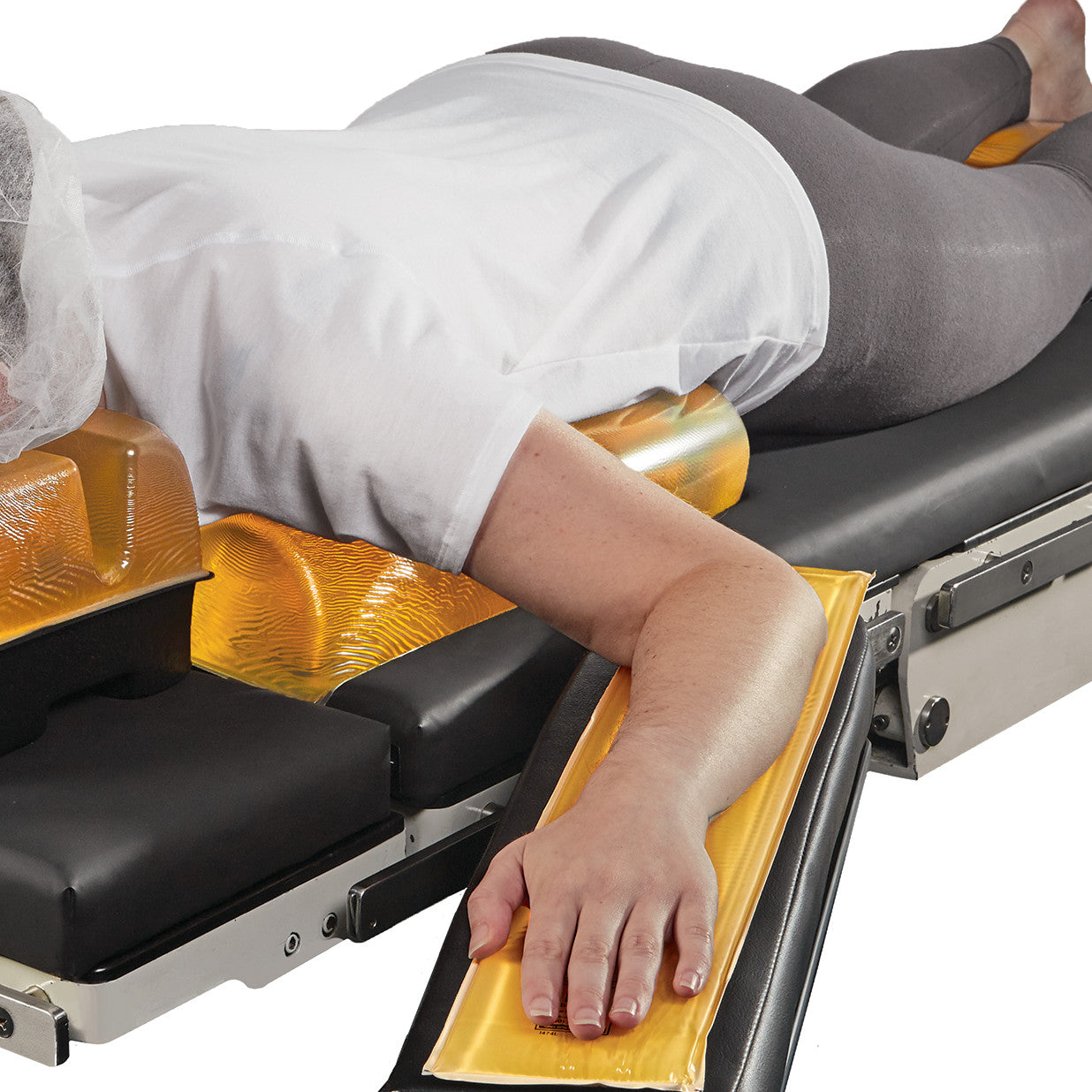 Person lying face down on a table using the AliMed AliGel Chest Roll, with orange gel pads for support under chest and arms.