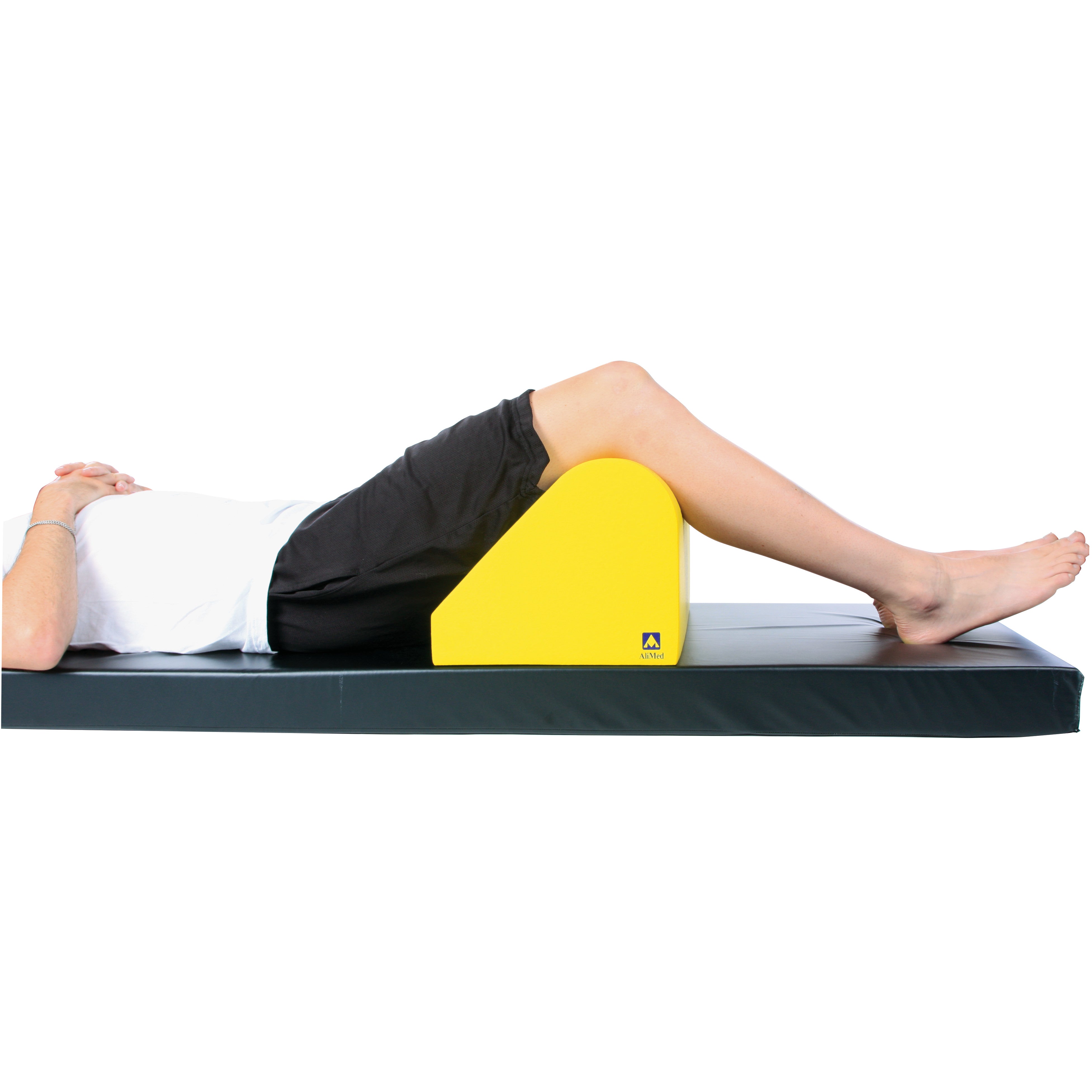 Person lying on a mat with legs supported by the yellow AliMed Protecta-Coat Standard Knee Bolster for knee elevation.