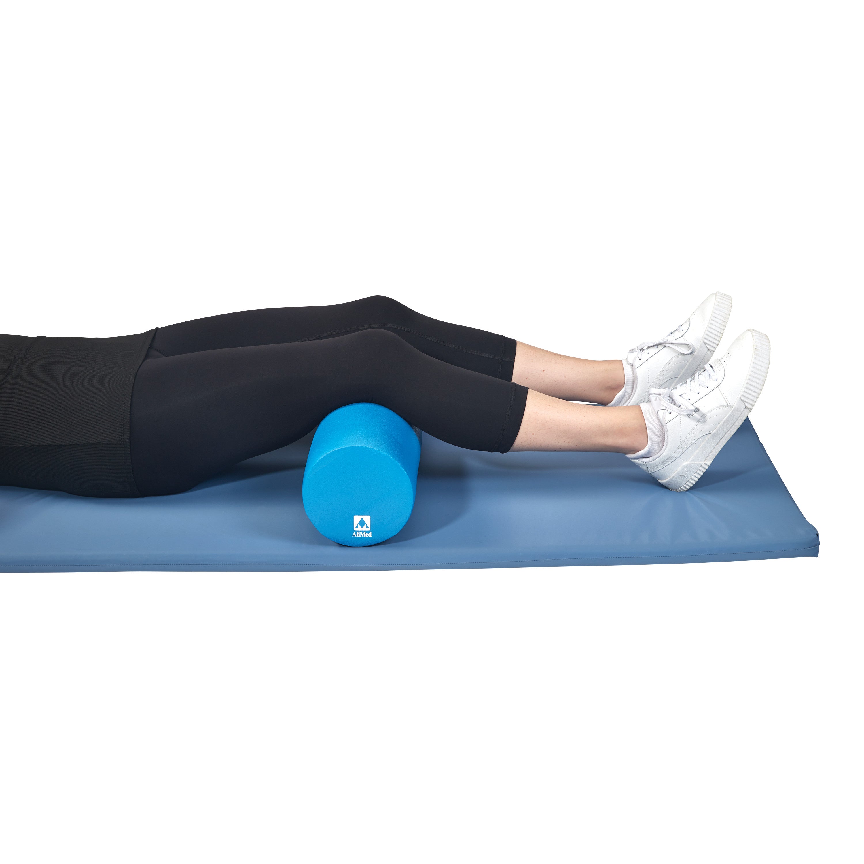 A person is lying on a blue mat with their calves resting on an AliMed Antimicrobial-Treated Therapy Positioning Roll.