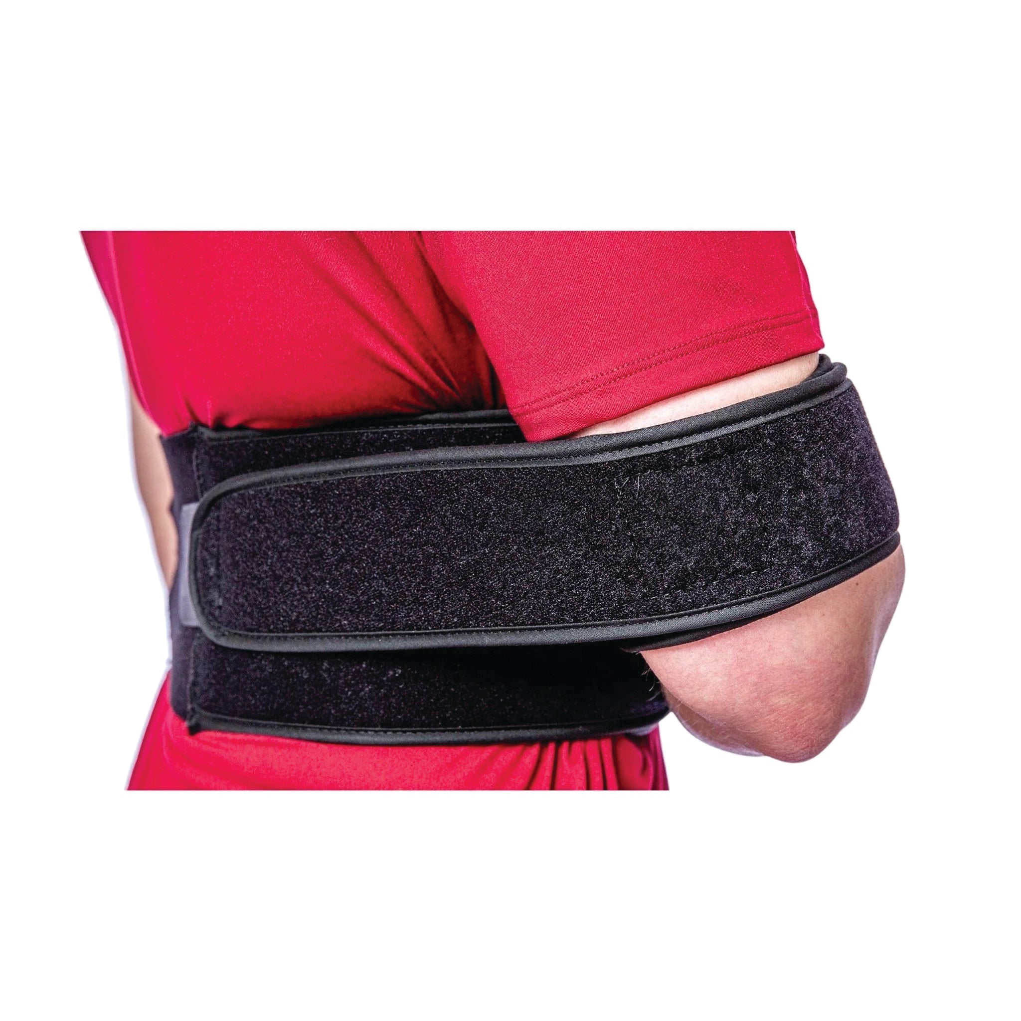 A person wearing a red shirt uses an Elastic Torso Belt Shoulder Immobilizer to support their arm and shoulder.