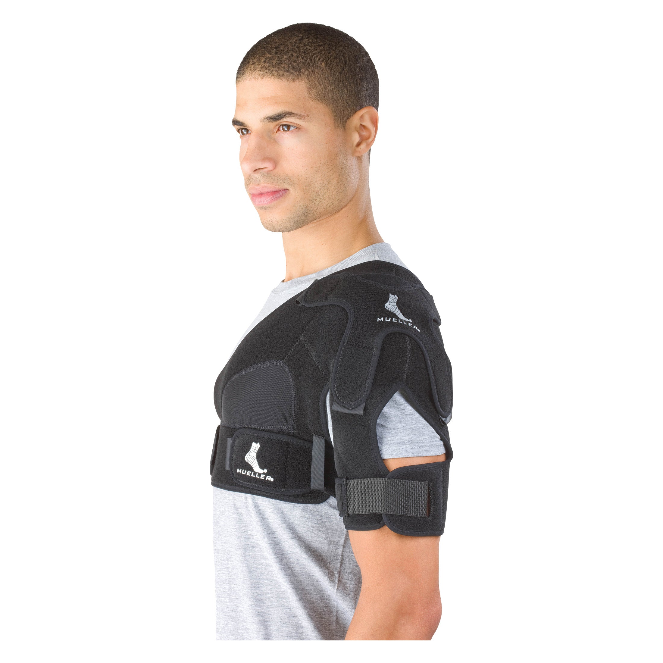 A person wearing a Mueller Shoulder Support brace, designed to provide stability and compression for shoulder injuries.
