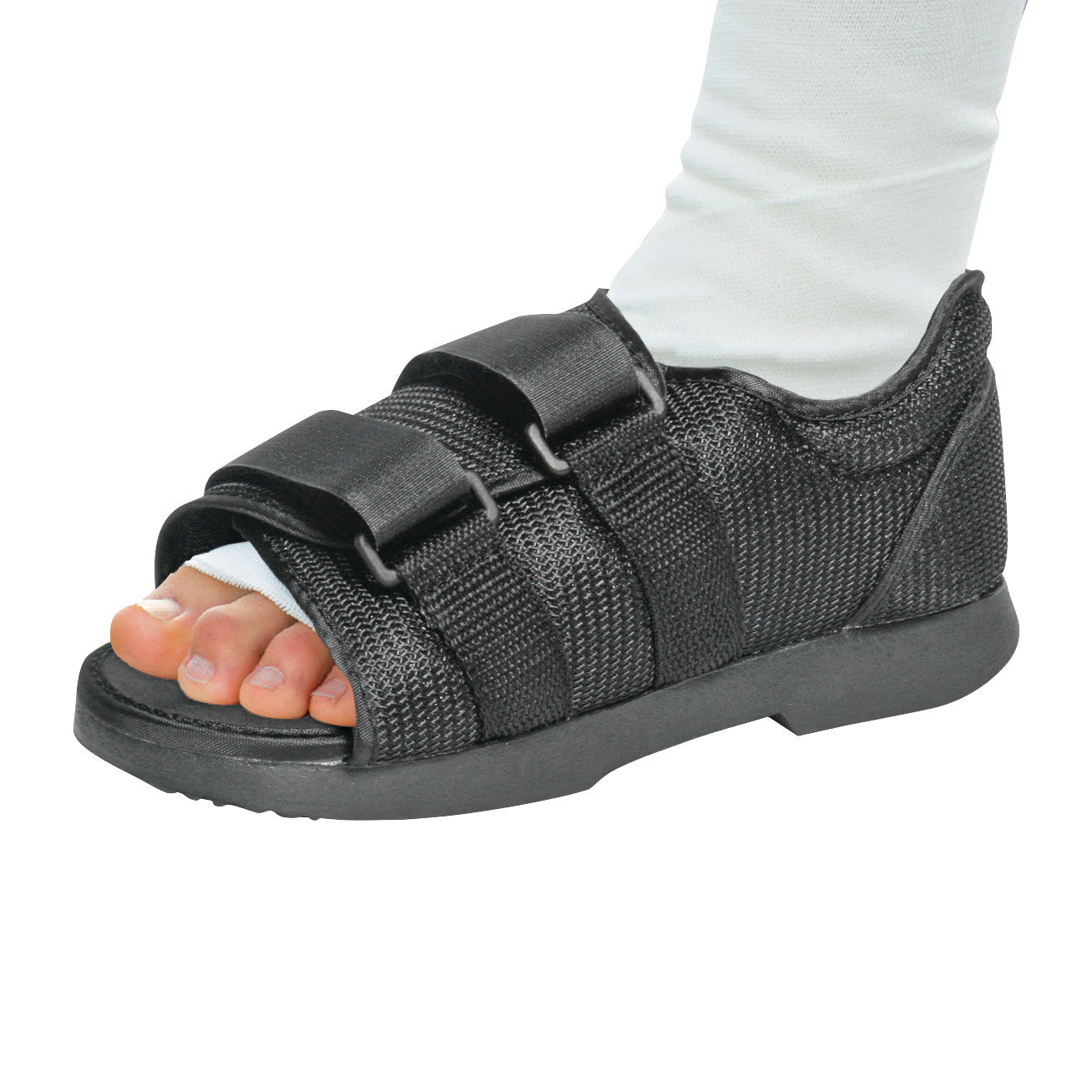 A foot wearing an AliMed Classic Post-Op Shoe with black fabric, open toes, and two adjustable straps over a white sock.