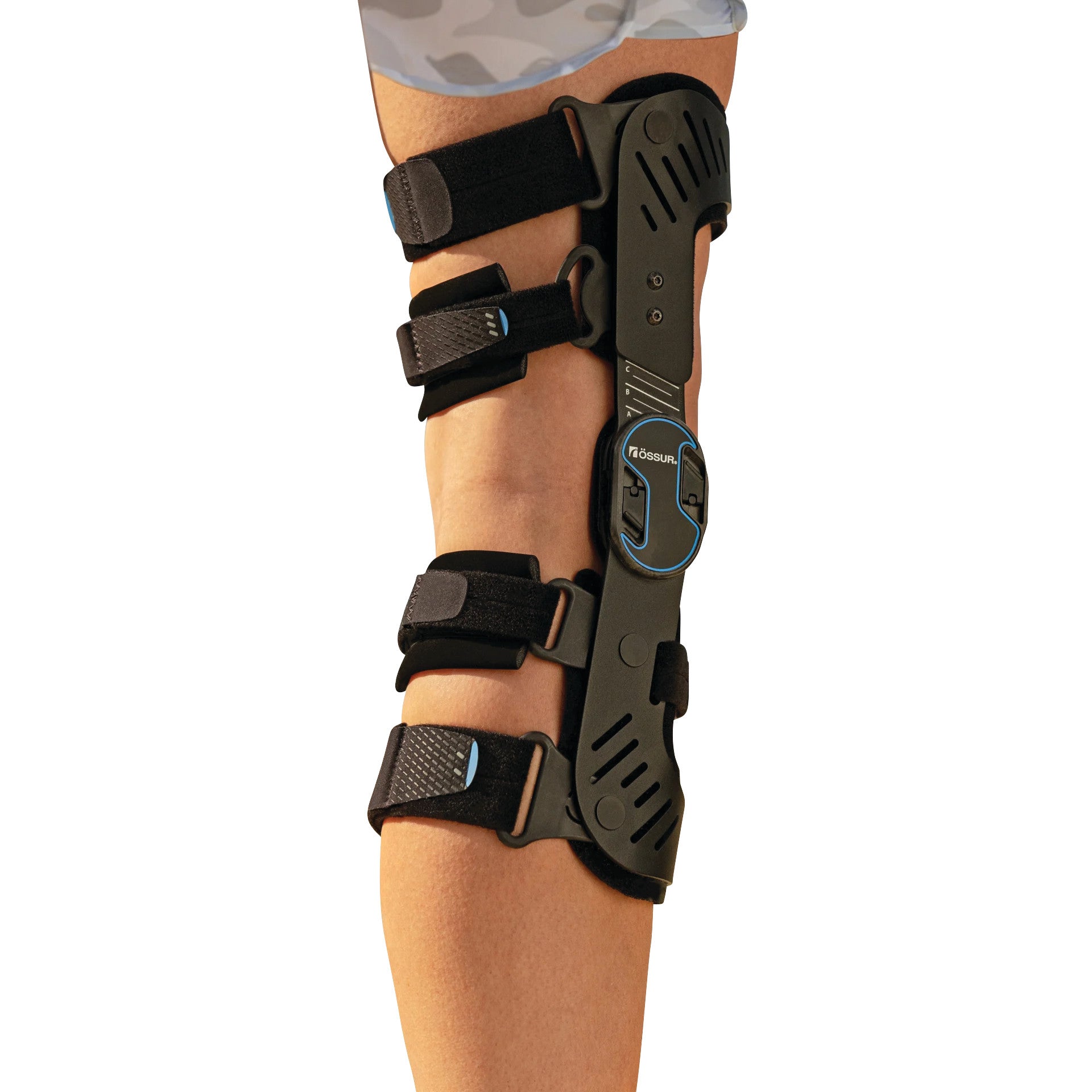 A leg wearing an OssurRebound DUAL Knee Brace with black straps and a blue accent on the side hinge.