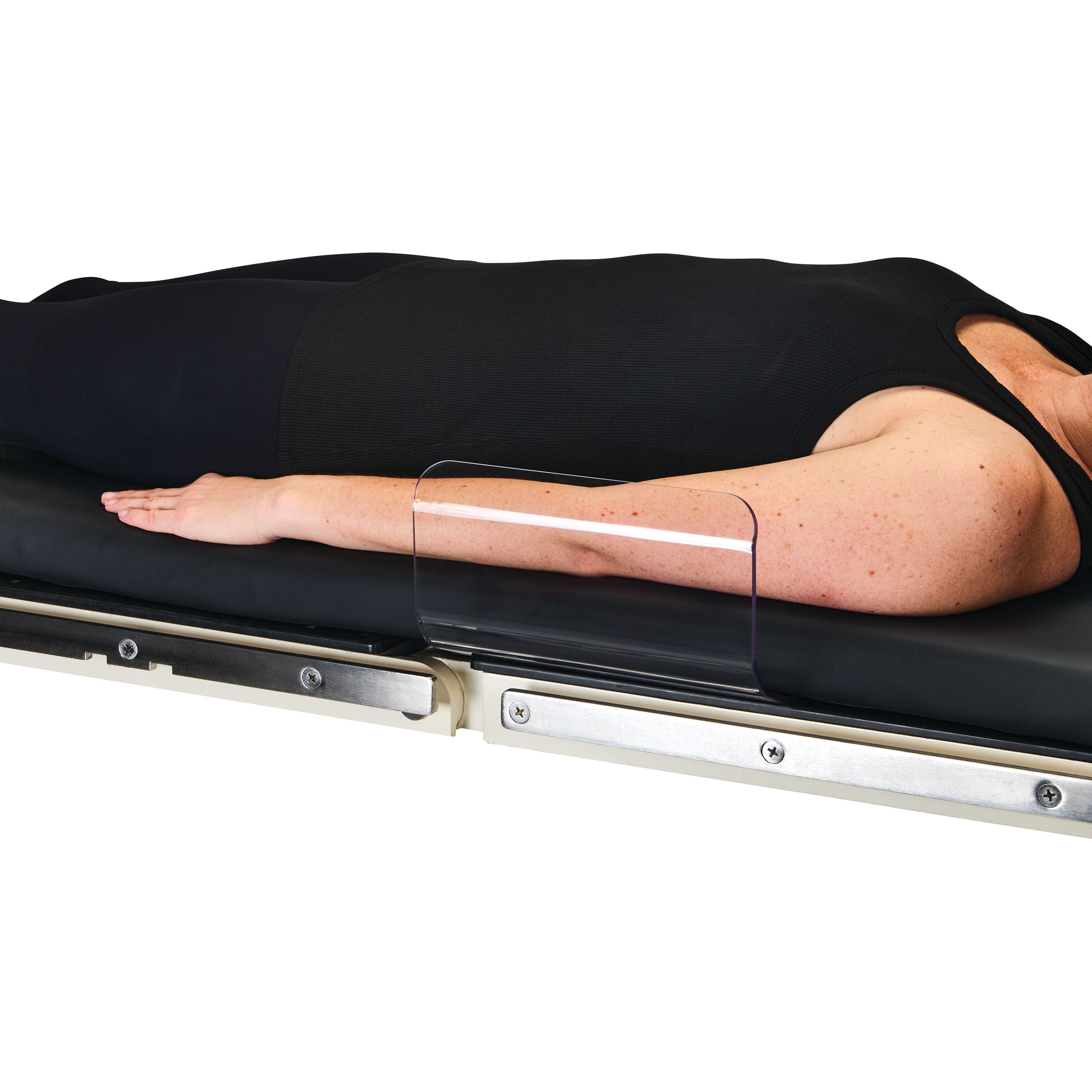 A person lies on a table with an AliMed Curved Toboggan Arm/Leg Guard protecting their arm, preventing it from falling off.