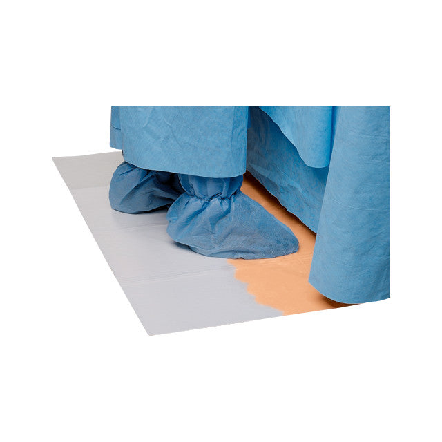 Feet covered with blue surgical booties stand on a SANDEL DriFloor Absorbent Pad, which absorbs liquid to keep the floor dry.