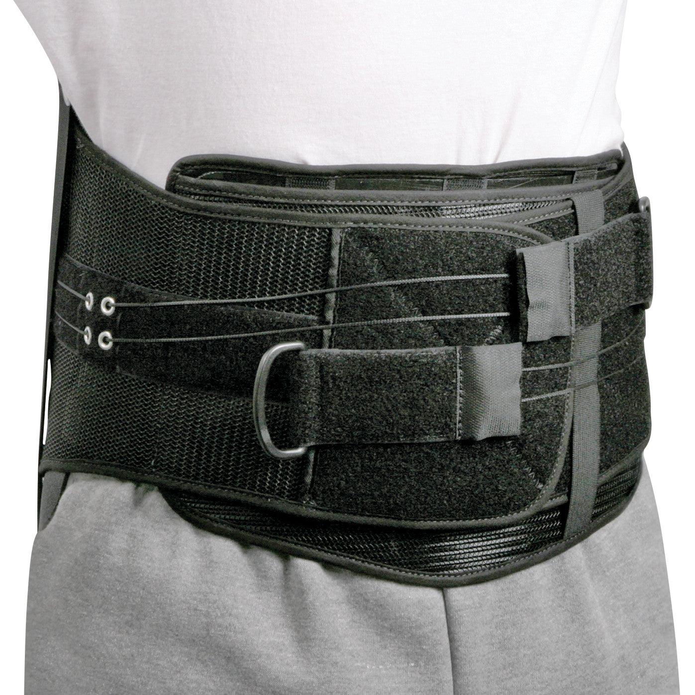 A person wears the AliMed Shadow Modular Spinal System, a black back brace designed for lumbar support with adjustable straps.