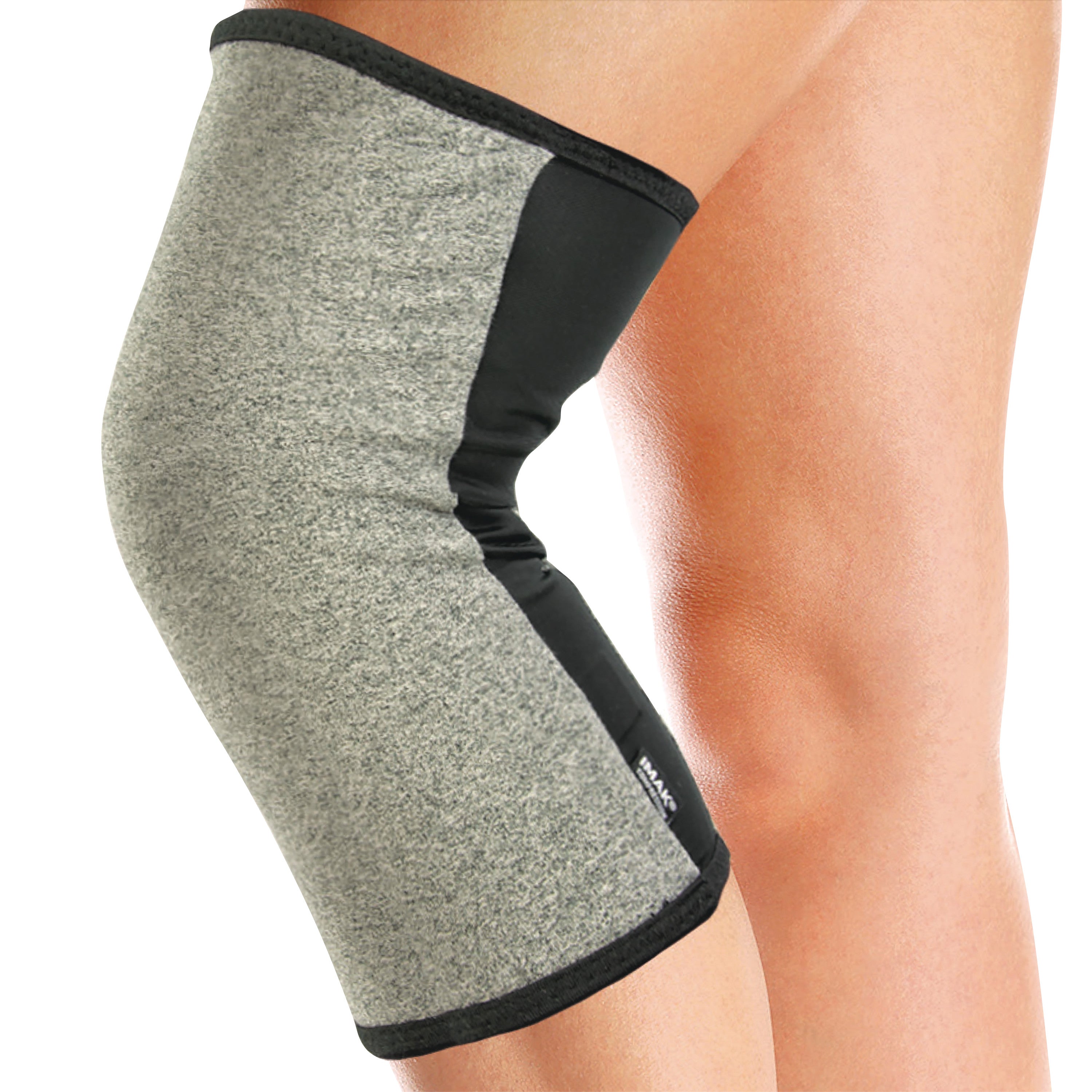 A person wears a Brownmed IMAK Compression Arthritis Knee Sleeve, shown in gray and black, providing knee support.