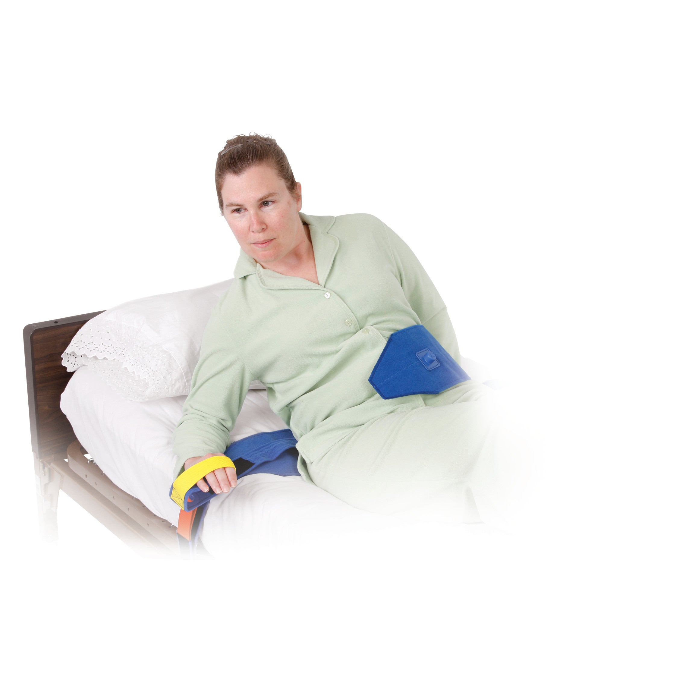 A person in pajamas uses the AliMed Roll-Control Belt, lying partially inclined on a bed for posture support.