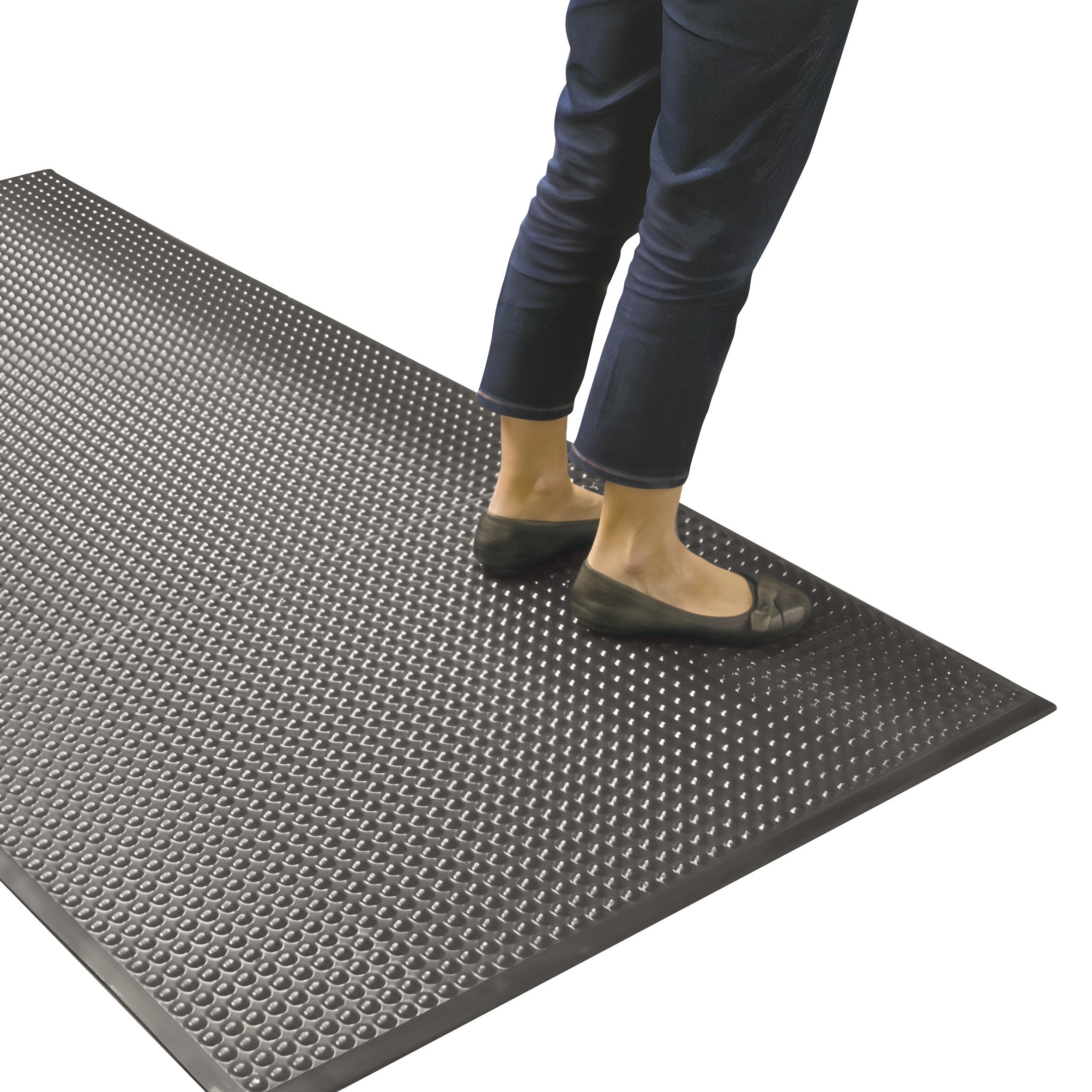 A person stands on the ERGOMAT Basic Bubble Anti-Fatigue Mat. The mat is black with a textured bubble surface.