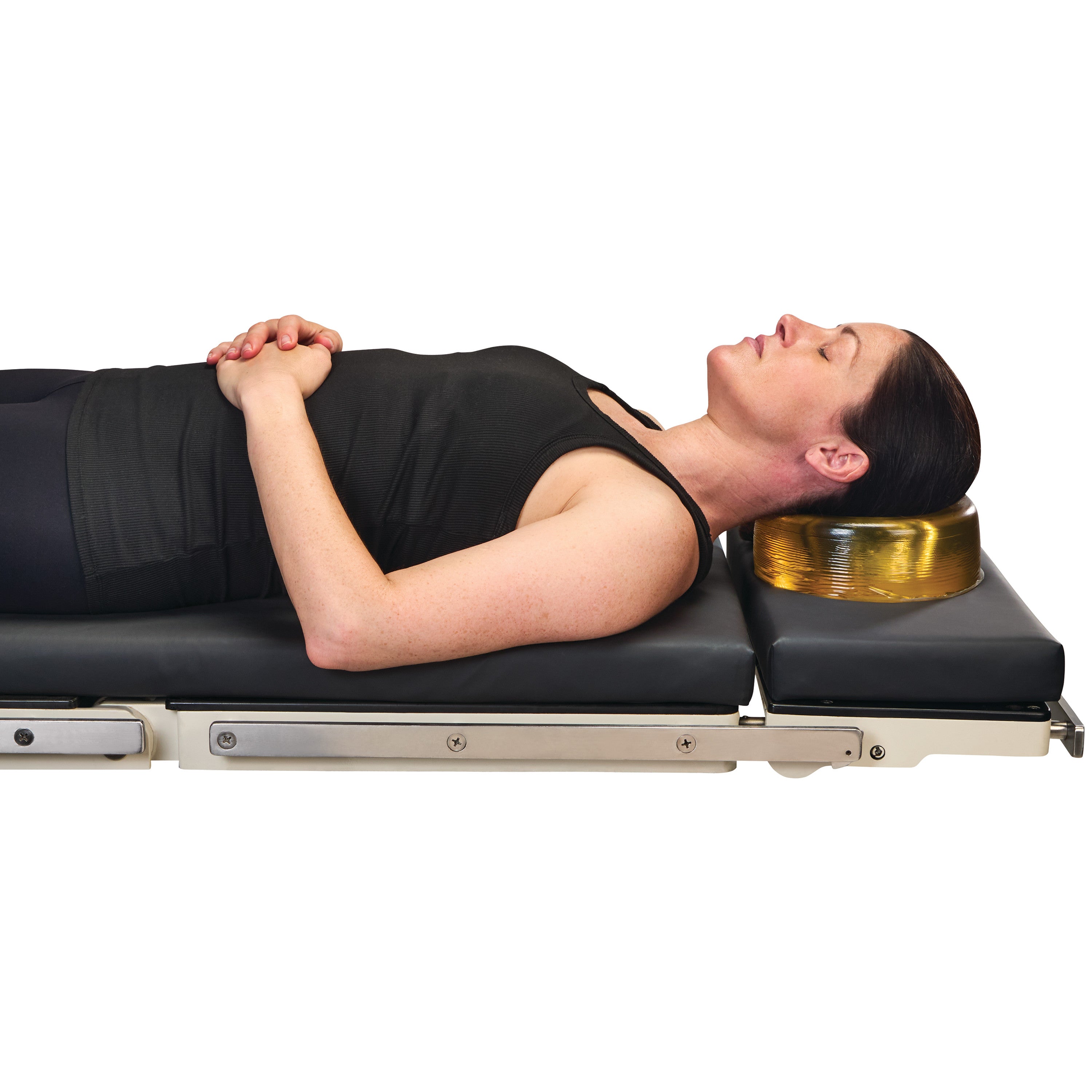 A woman lies on her back with her head supported by an AliMed AliGel Head Donut, positioned on a cushioned surface.