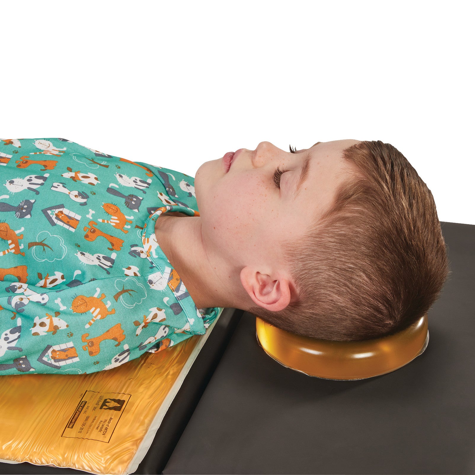 A child rests their head on the AliMed AliGel Head Donut. The child is lying on a surface, wearing a shirt with animal prints.