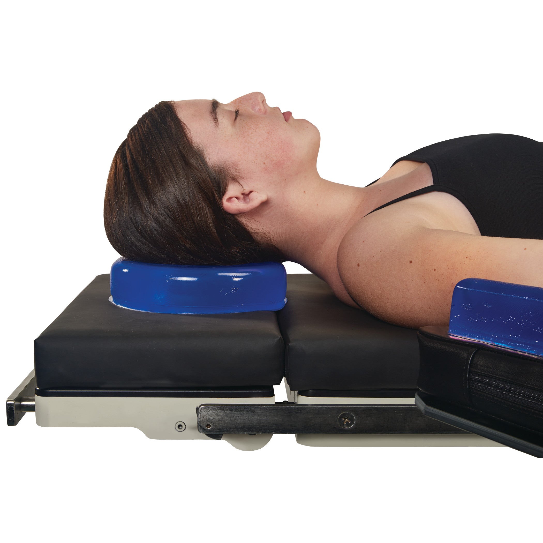 A person rests their head on the AliMed AliBlue Gel Head Donut, positioned on a black cushion, demonstrating its use.