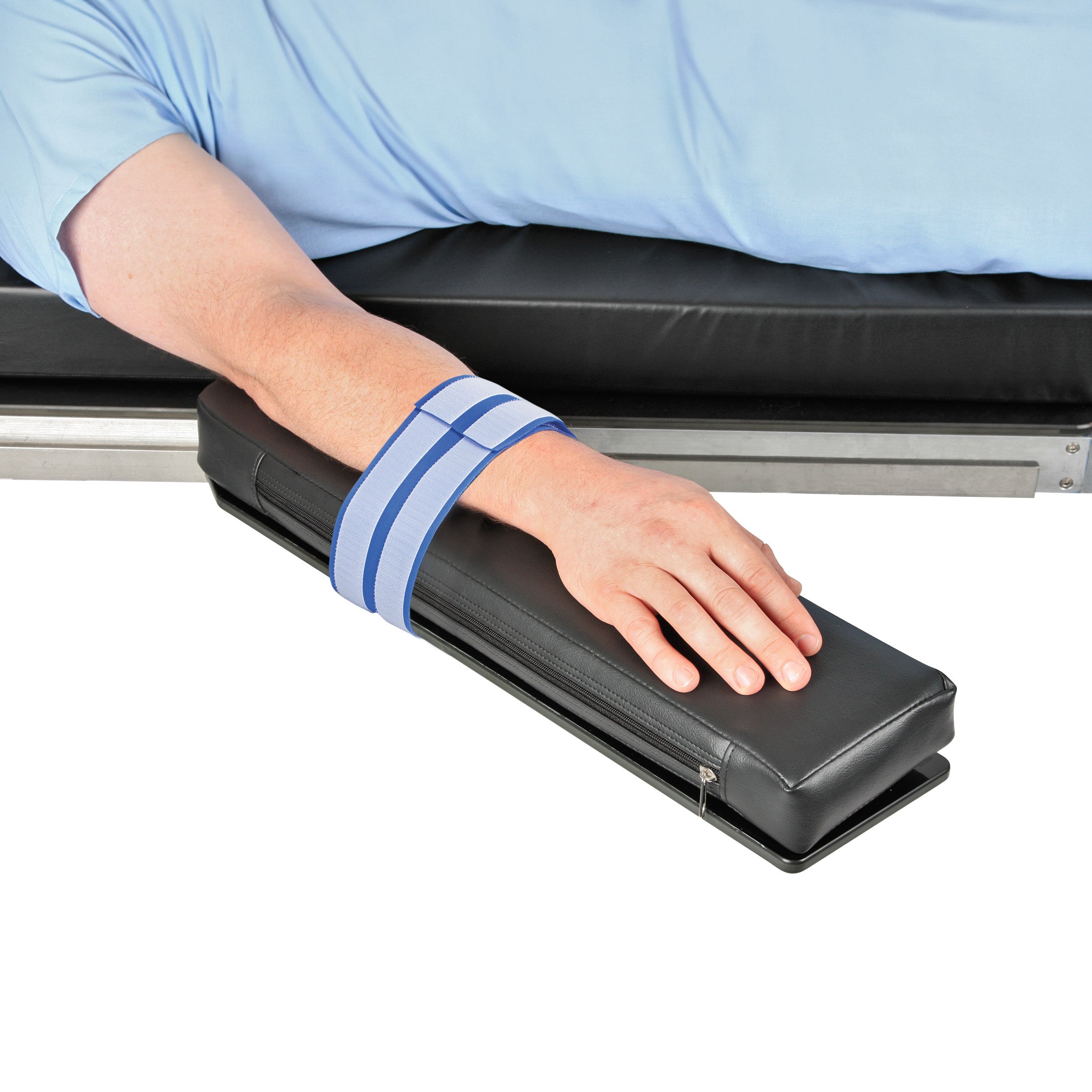 A person's arm is secured on a padded platform using the AliMed AliStrap Positioning Strap, aiding in stability and support.
