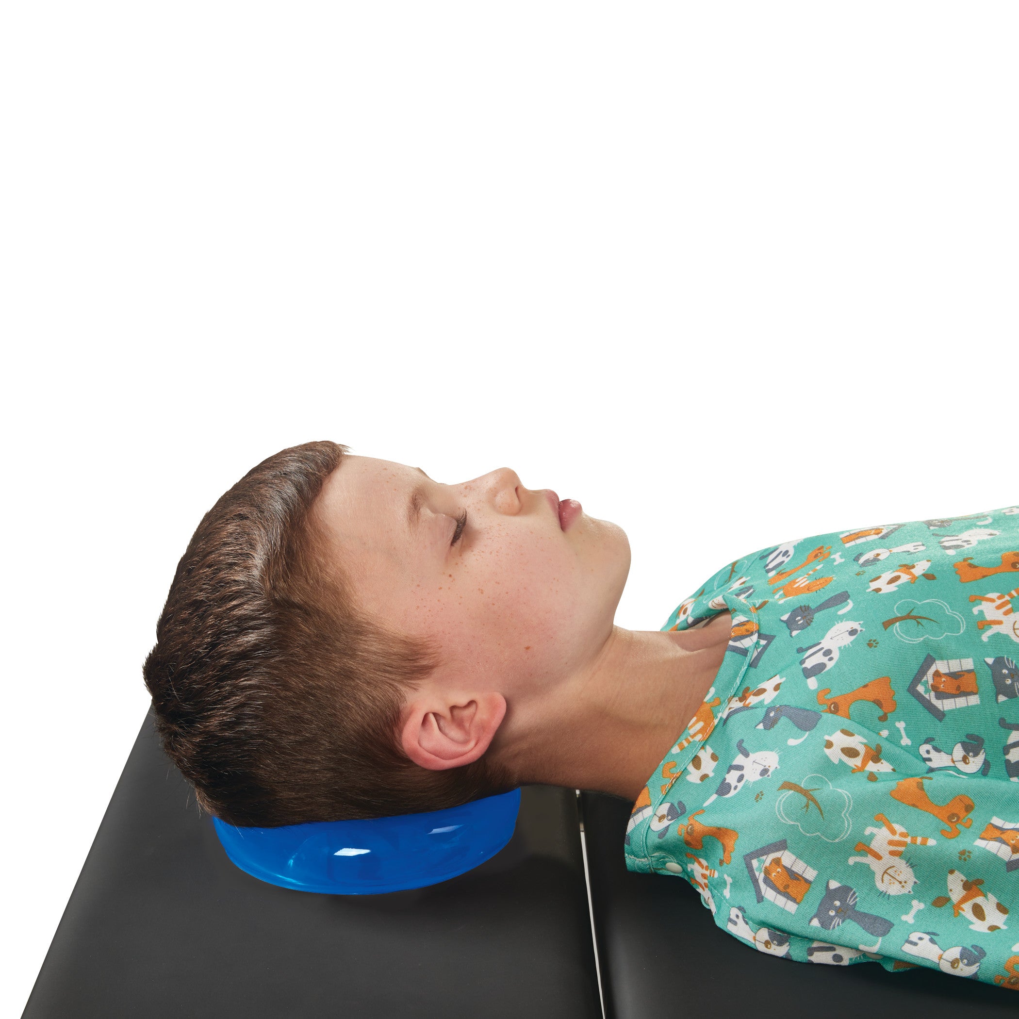 A child rests their head on the AliMed AliBlue Gel Head Donut, which is placed on a black surface.